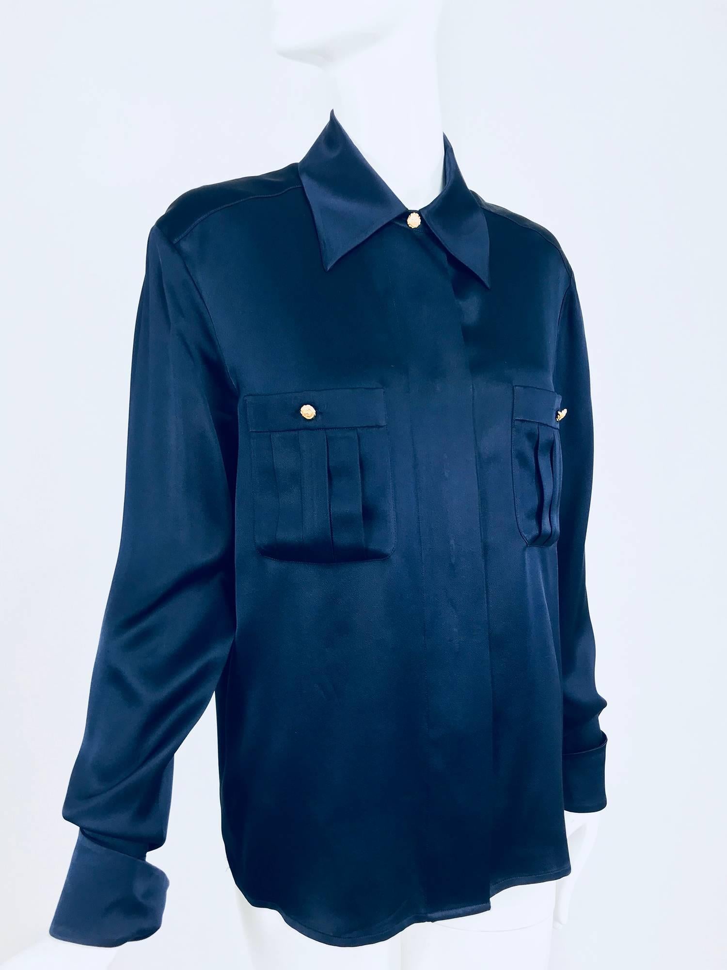 Chanel dark blue silk satin blouse with gold logo buttons...Hidden button front placket blouse with collar, long full sleeves with turn back cuffs and double buttons...Double breast pockets with buttons at the front...Fits a size small-medium, check