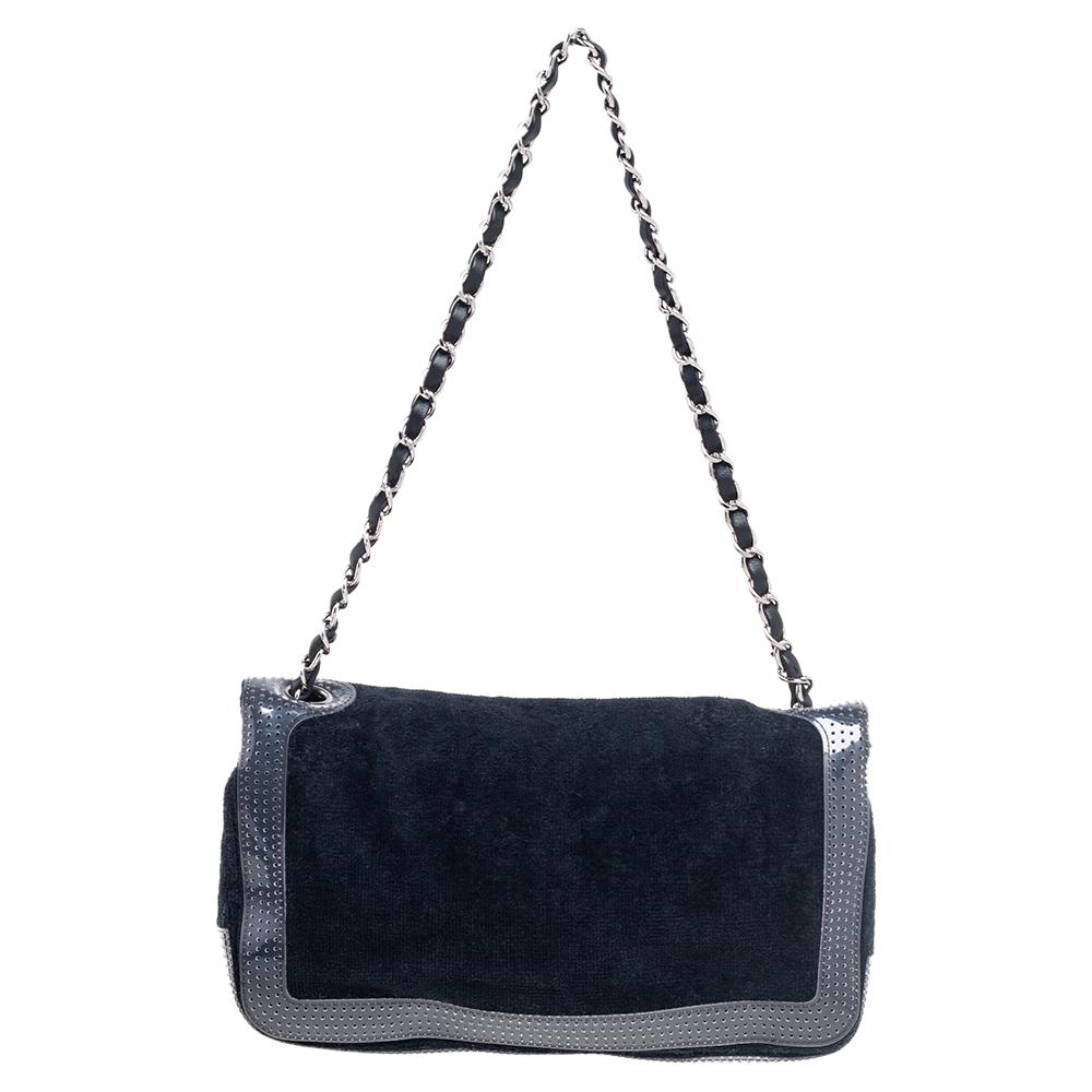 This CC shoulder bag from Chanel will add luxurious vibes and a stylish statement to your handbag collection. This bag is made using dark-blue terry cloth and perforated PVC on the exterior with a logo print detail on the front. It is supported by a