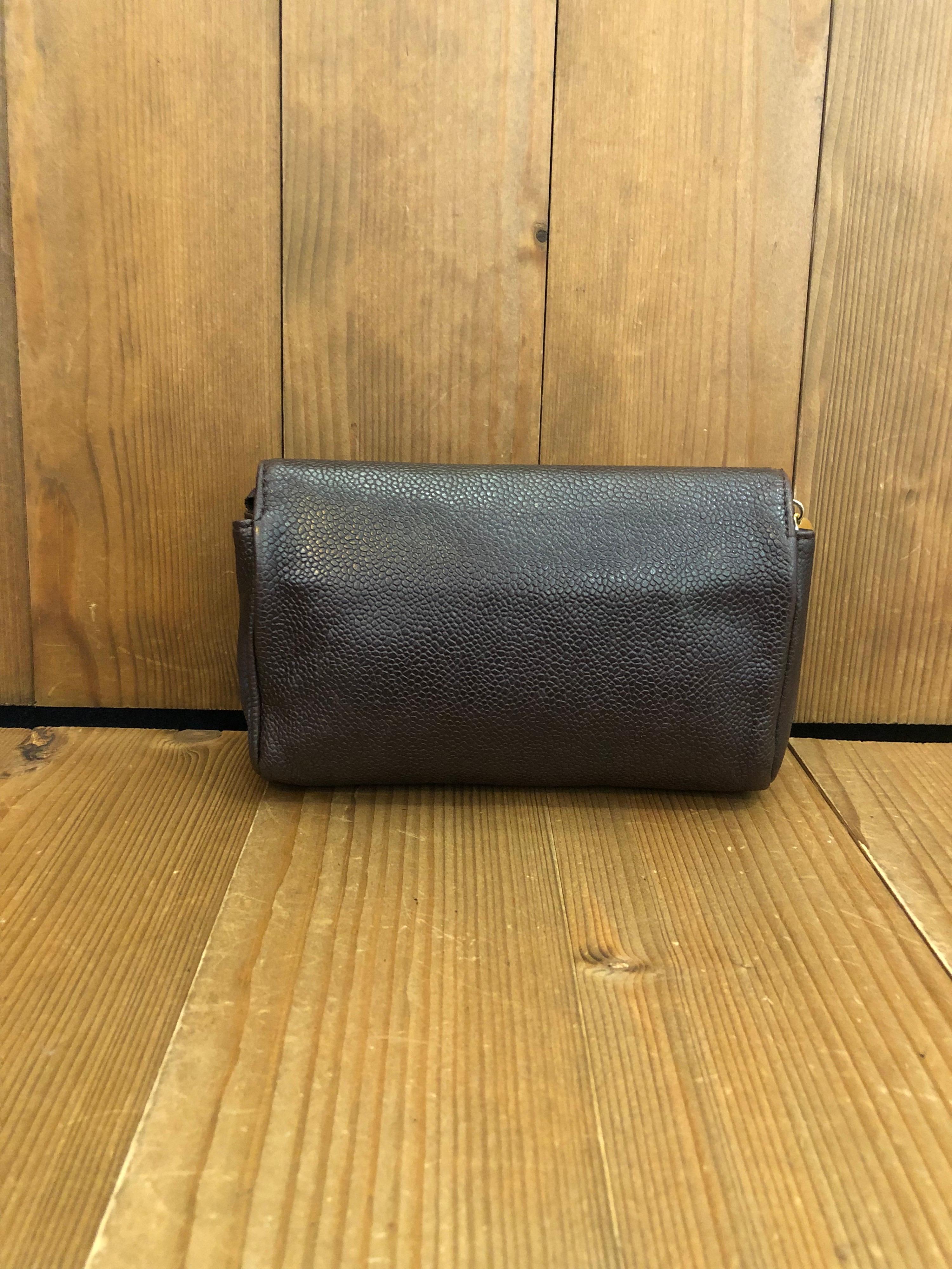 1990s Chanel cosmetic pouch/clutch in dark brown caviar leather with lambskin leather interior featuring a minor under the flap. Made in Italy. Serial sticker illegible.  Measures 6.5 x 4.5 x 2 inches (fits plus sized iPhone). 

Condition: Some