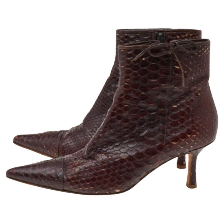 Add a high-end update to your look with these ankle boots from Chanel. Crafted from python leather, these brown designer ankle boots feature pointed toes and side zip closure. They are elevated on low heels and luxuriously lined for a comfort-laden