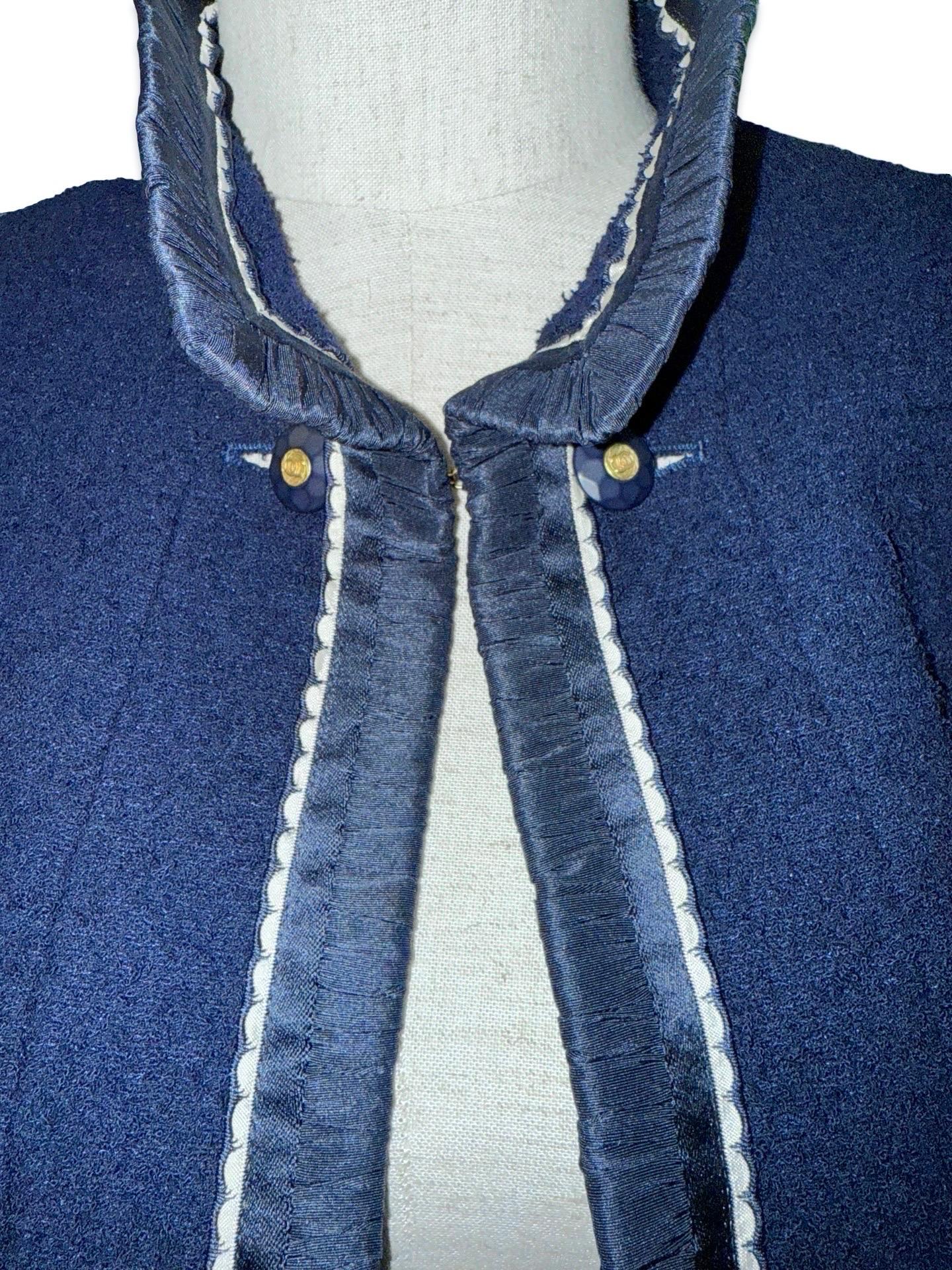 - Chanel by Karl Lagerfeld veste en laine bouclée marine foncée de la collection 1994. Il a été présenté lors de défilés et a fait l'objet d'articles dans des magazines. 

- Ruban de satin bordé d'un liseré festonné. 

- Quincaillerie dorée,