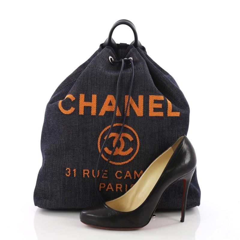 This authentic Chanel Deauville Backpack Denim Large is an excellent backpack, perfect for everyday use and all your essentials. Crafted in blue denim, this lovely backpack features a rolled top handle, leather shoulder straps, Chanel logo and store