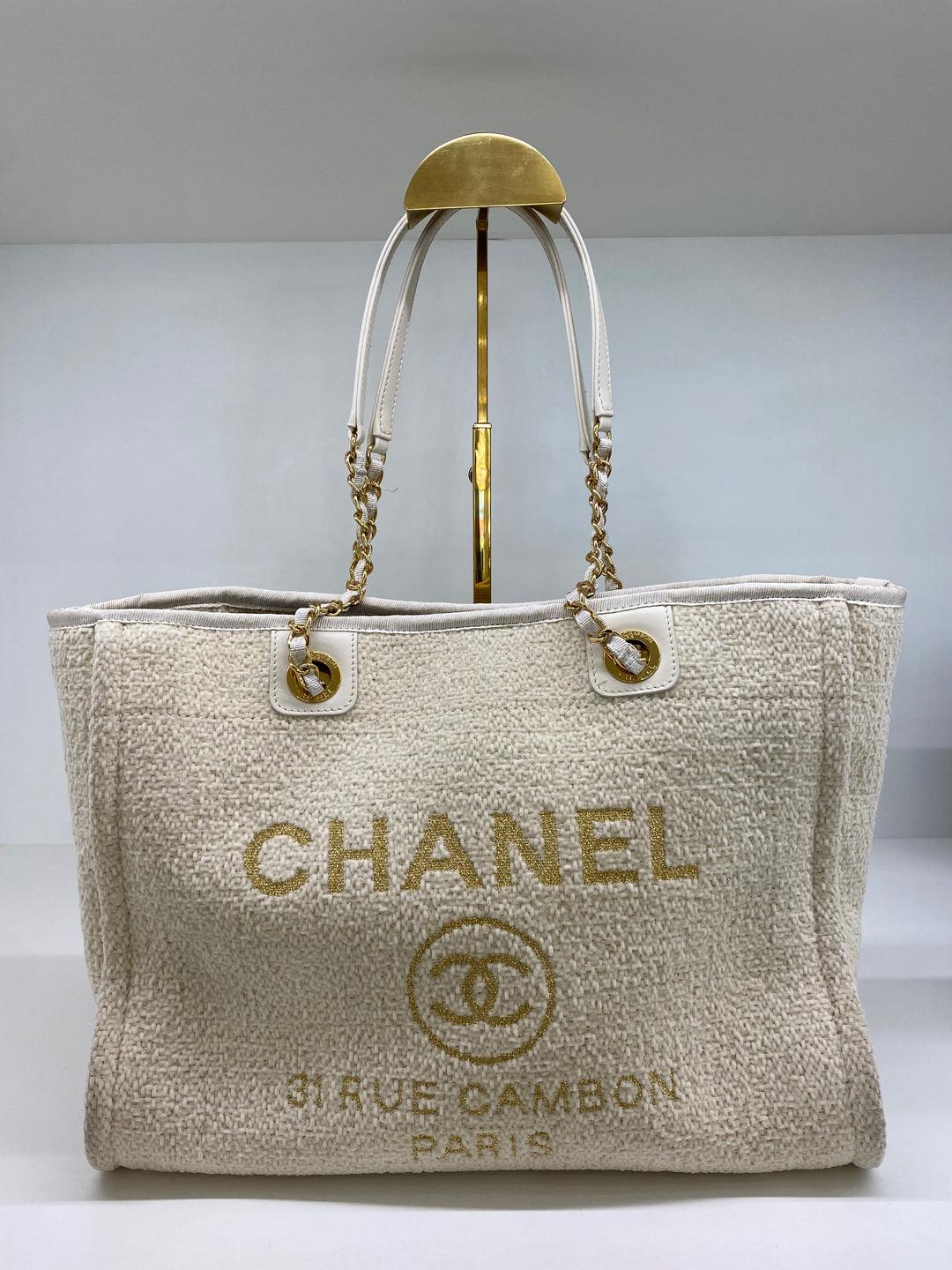 Chanel Deauville from the 19A Collection. Crafted in beautiful beige boucle (similar to tweed) with gold lurex threading throughout giving a sparkle all around the bag. Gold Chanel logo, gold hardware and elegant burgundy lining. 

Condition: Great