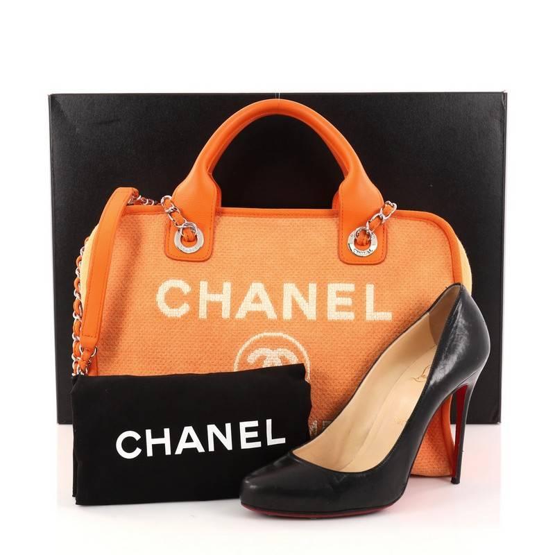 This authentic Chanel Deauville Bowling Bag Canvas Large embodies a casual chic style made for any fashionista. Crafted in lightweight orange canvas, this chic satchel features dual-rolled top leather handles, dual woven-in chain straps with leather