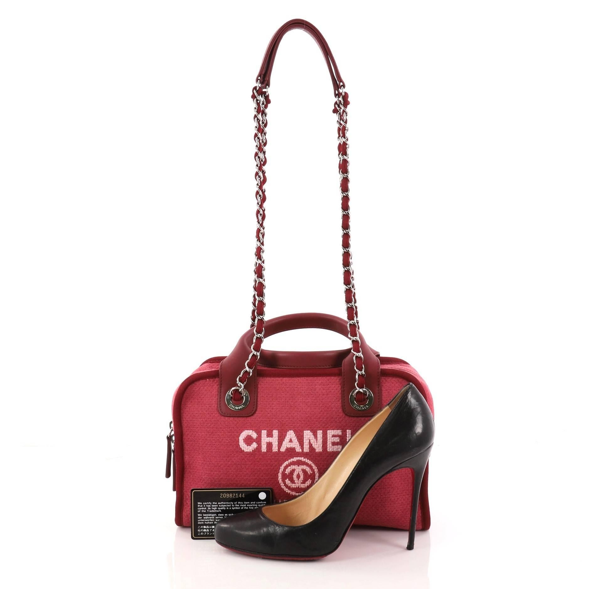 This authentic Chanel Deauville Bowling Bag Canvas Small embodies a casual chic style made for any fashionista. Crafted in lightweight red canvas, this chic satchel features dual-rolled top leather handles, dual woven-in chain straps with leather