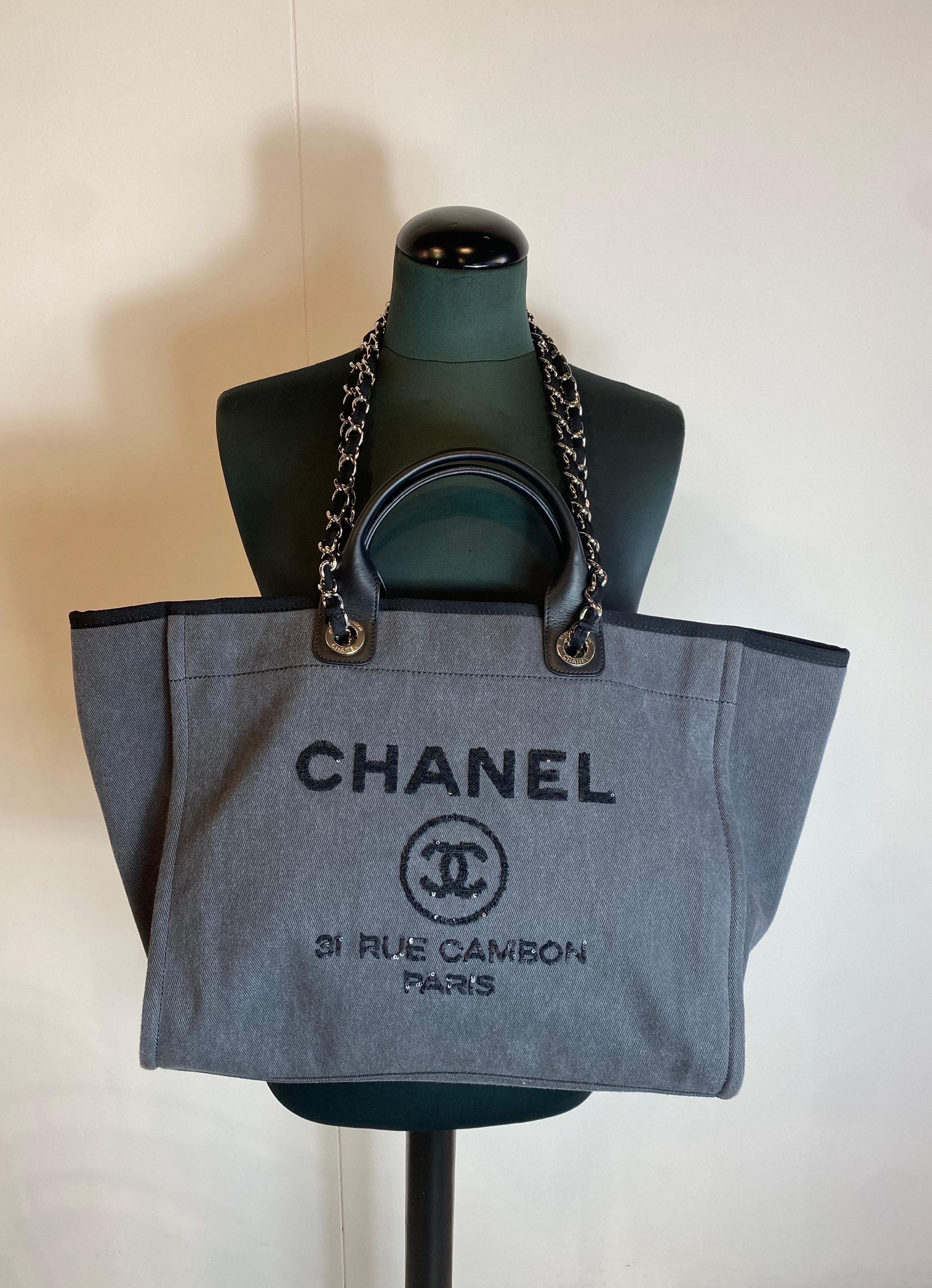 Chanel Deauville tote bag.
In gray fabric with black leather details.
The bag can be carried by hand or on the shoulder.
Magnetic closure.
The hardware has still transparent protective plastic.
Inside there are multiple pockets, one is closed with a