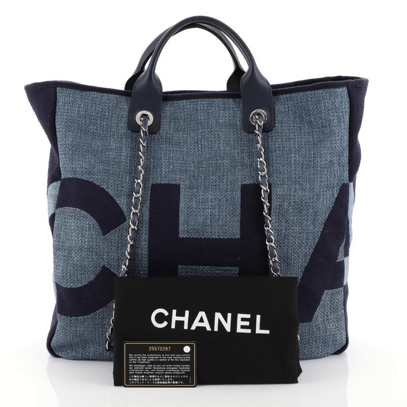 This Chanel Deauville Logo Shopping Tote Printed Raffia Large, crafted from blue printed raffia, features dual rolled leather handles, dual woven-in leather chain straps with leather pads, and silver-tone hardware. It opens to a blue fabric and