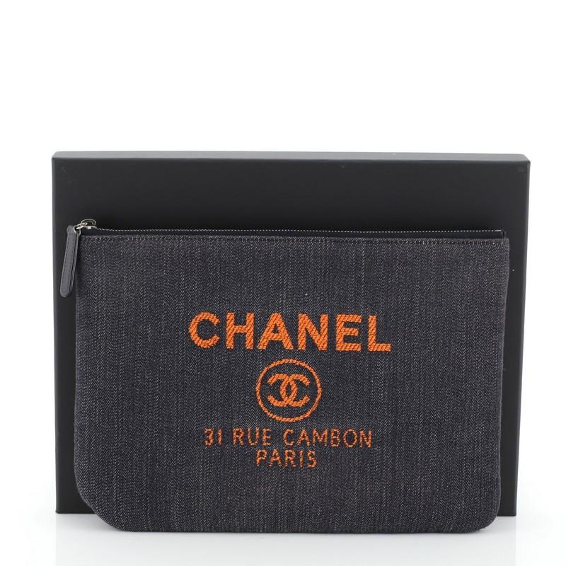 This Chanel Deauville Pouch Denim Medium, crafted from blue denim, features orange Chanel logo detailing and silver-tone hardware. Its zip closure opens to an orange quilted nylon interior. Hologram sticker reads: 23922382. 
Condition: Excellent.