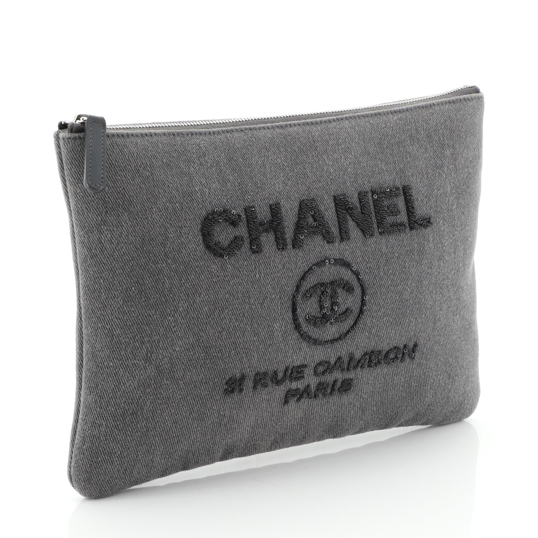 This Chanel Deauville Pouch Denim with Sequins Medium, crafted from gray denim, feature sequin Chanel logo detailing and silver-tone hardware. Its top zip closure opens to a gray nylon interior. Hologram sticker reads: 24126986. **Note: Shoe