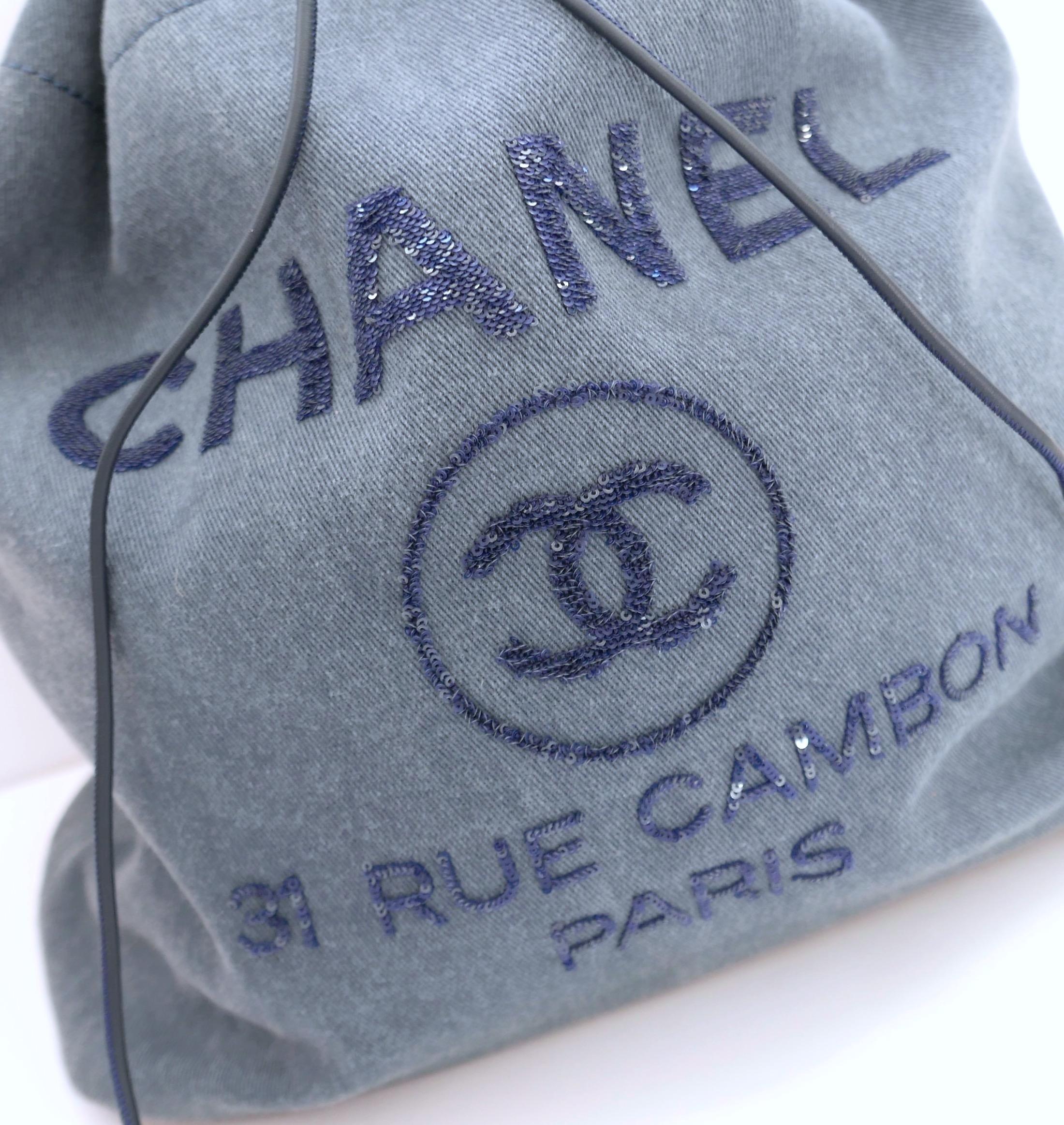 Sac à dos en denim Chanel Deauville très cool. Nouveau avec carte d'authenticité. Confectionné en denim bleu vintage doux avec un superbe logo en paillettes, des ferrures argentées, des garnitures en cuir ton sur ton, deux bandoulières plates avec