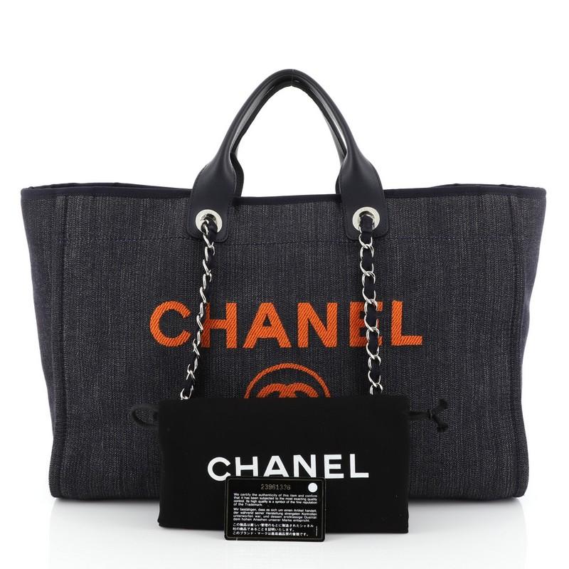 This Chanel Deauville Tote Denim Medium, crafted in blue denim, features dual flat leather handles, woven-in chain link straps, embroidered CC logo with Chanel's famous Parisian store address and silver-tone hardware. Its magnetic snap closure opens
