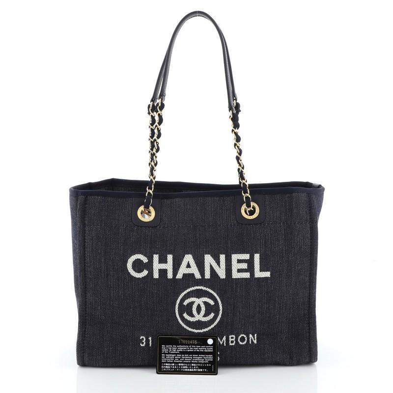 This Chanel Deauville Tote Denim Small, crafted from blue denim, features woven-in denim chain link straps with shoulder pads, CC logo with Chanel's famous Parisian store address and gold-tone hardware. Its magnetic snap closure opens to a neutral