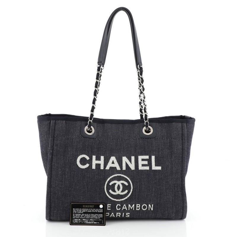 This Chanel Deauville Tote Denim Small, crafted from blue denim, features woven-in canvas chain link straps with shoulder pads, embroidered CC logo with Chanel's famous Parisian store address and silver-tone hardware. Its magnetic snap closure opens
