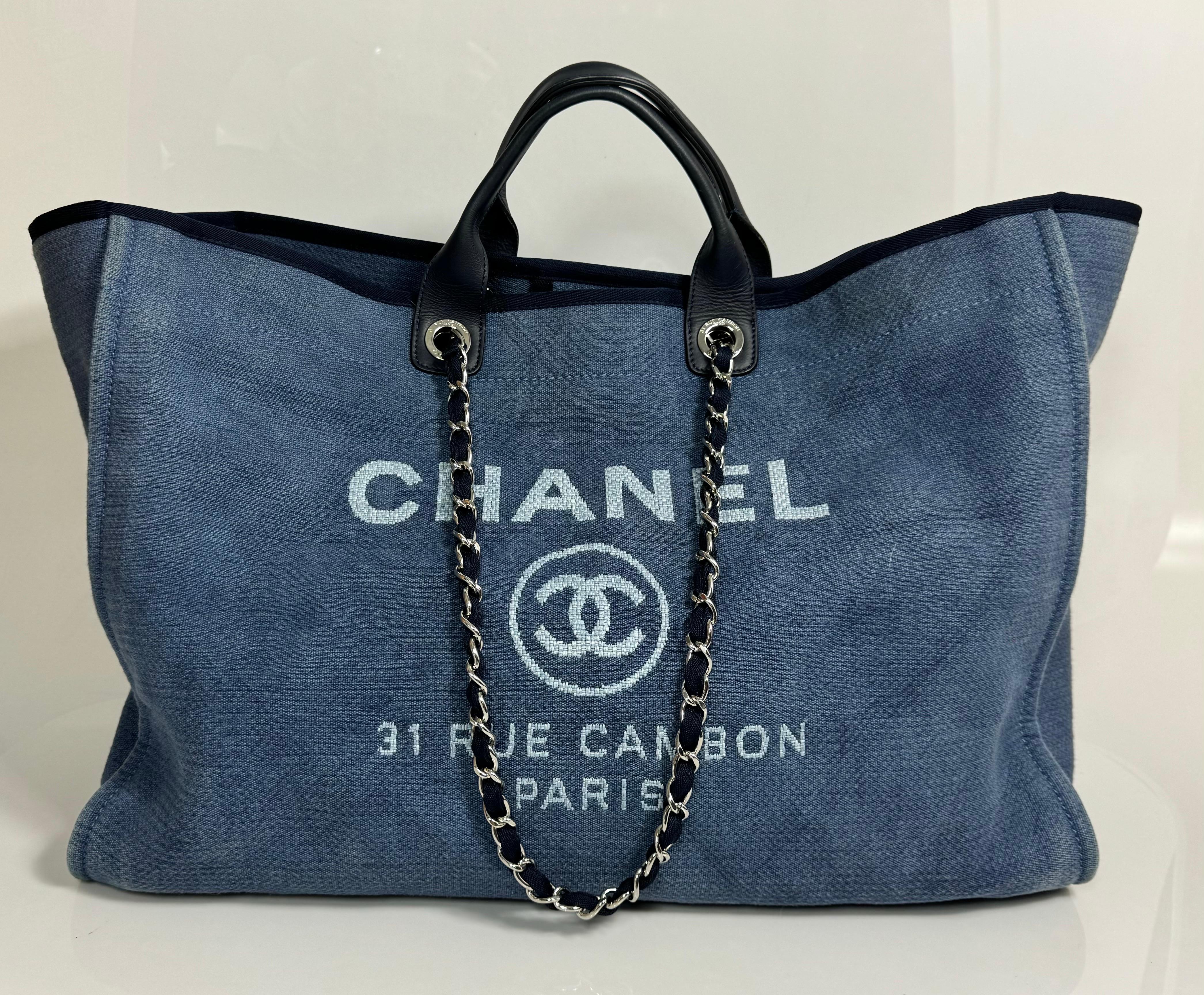 Chanel Denim Blue XL Deauville Tote - Circa 2012 This very popular Chanel tote is made from a denim blue canvas with white Lettering/Logo. The design of the tote bag has an open top that has an interior large snap, rolled leather top handles, and a