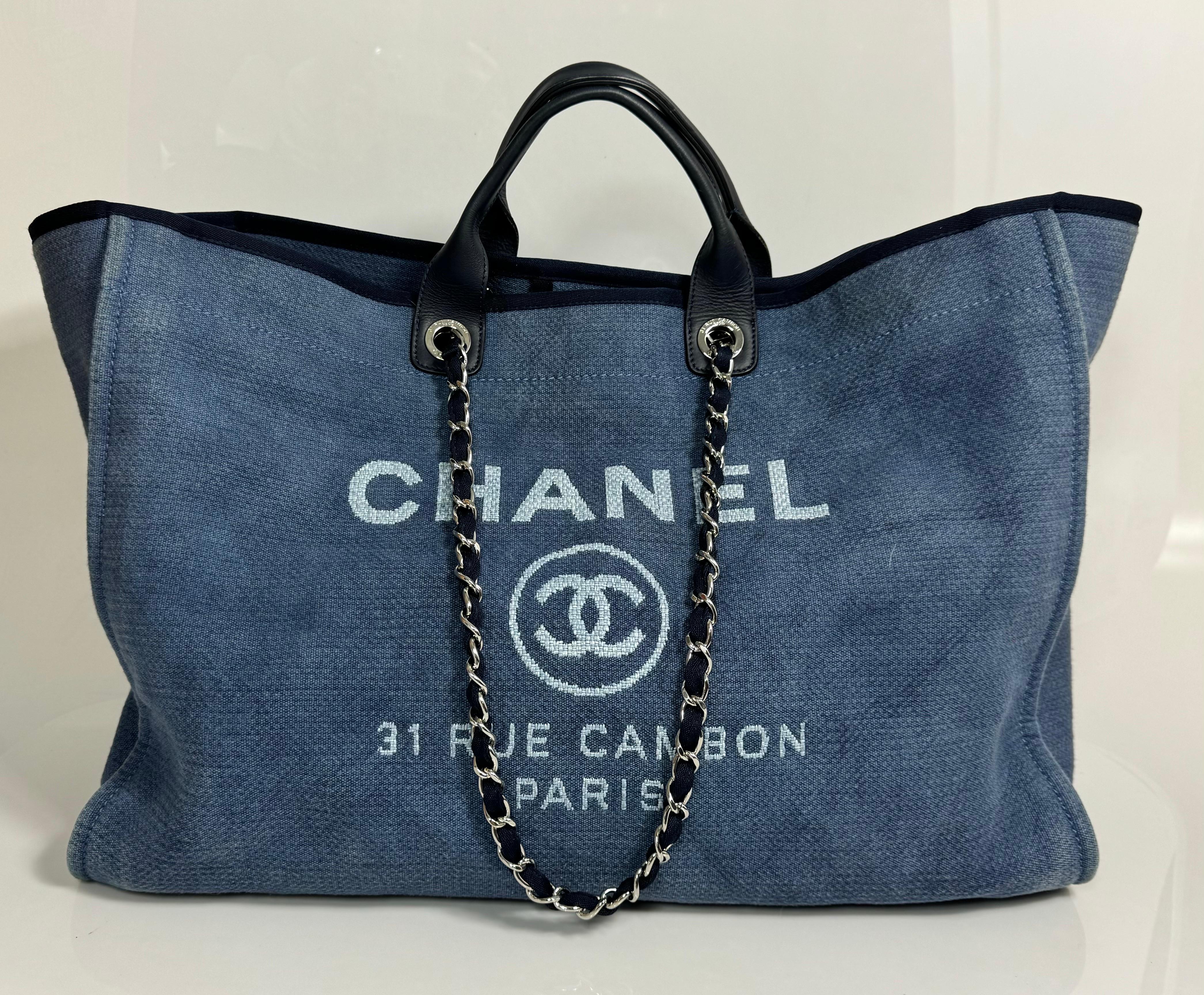 Chanel Denim Blue XL Deauville Tote - CIRCA 2012 Diese sehr beliebte Chanel-Tasche ist aus jeansblauem Canvas mit weißem Schriftzug/Logo gefertigt. Das Design der Tasche hat eine offene Oberseite mit einem großen Druckknopf im Inneren, gerollte