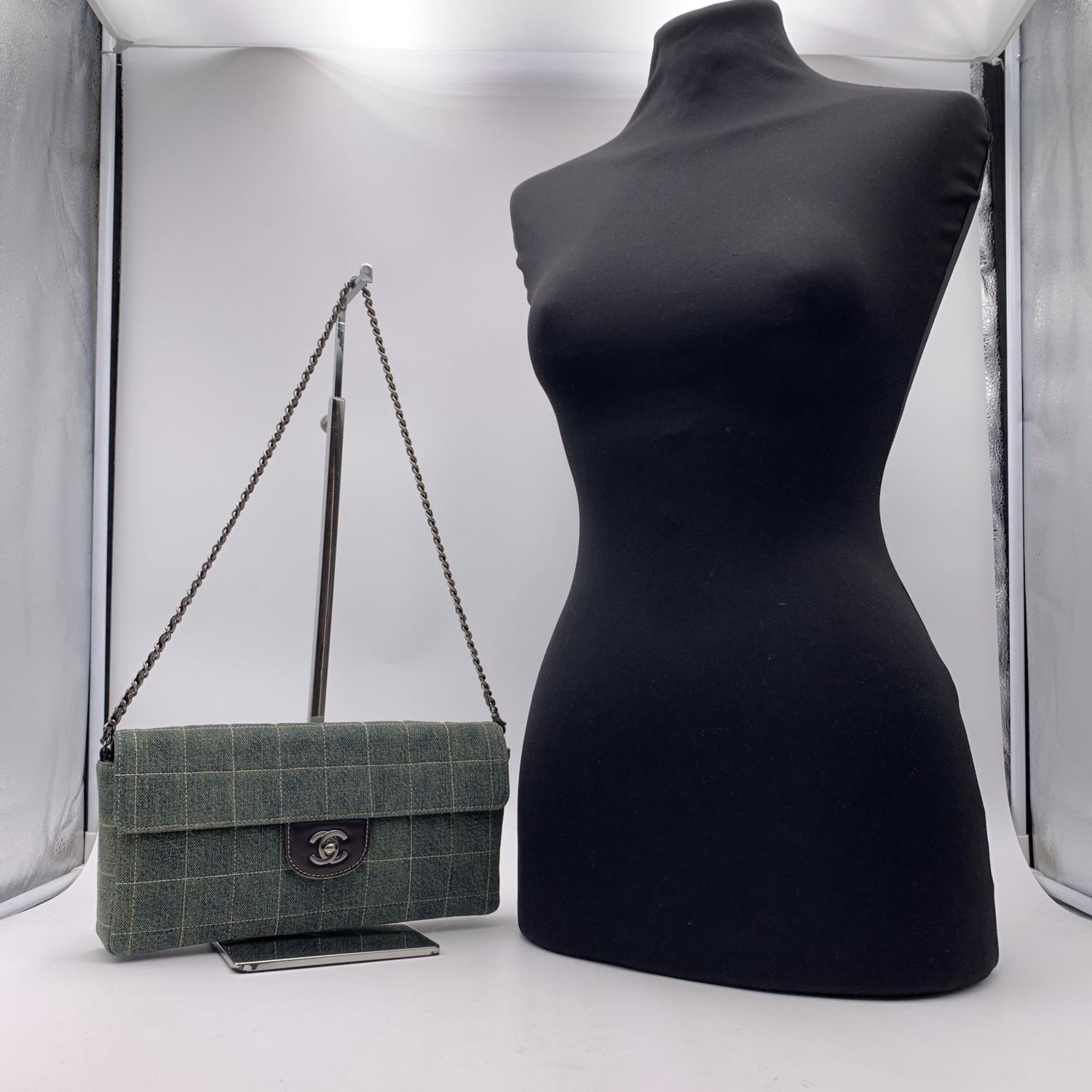 Chanel denim Chocolate Bar Quilting East West Shoulder Bag or Clutch. Period/Era: 2000/2002. Crafted from square quilted light blue denim canvas and gunmetal hardware. Flap with CC - CHANEL turn-lock clsoure at front. Removable leather-threaded