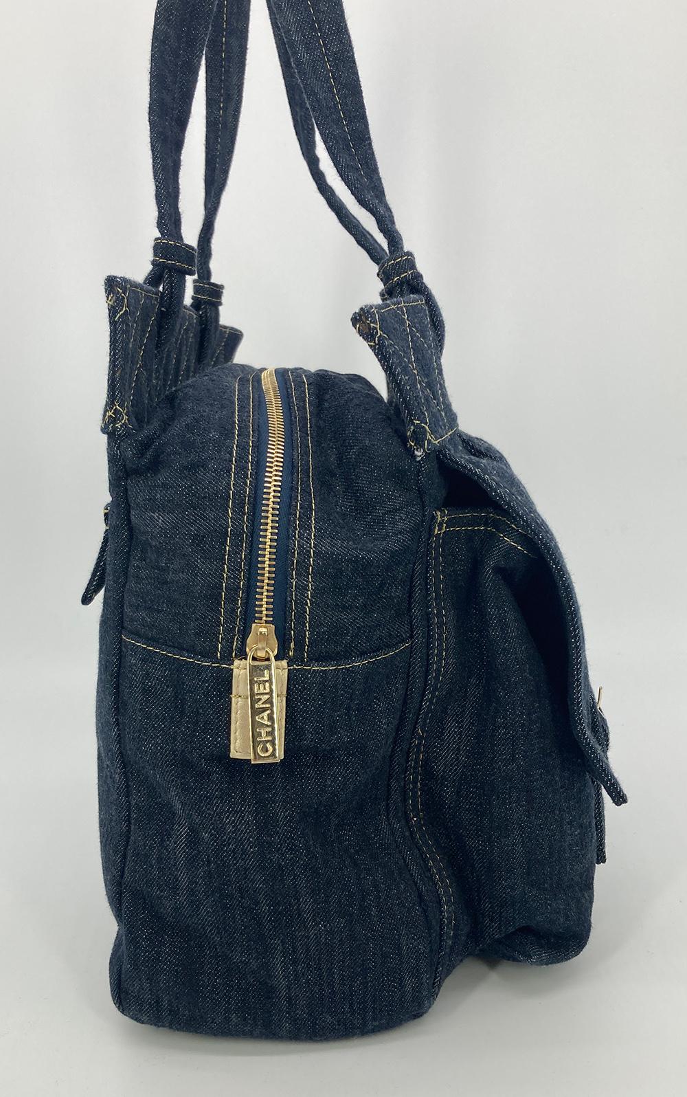 Chanel Denim Double Pocket Tote in excellent condition. Blue jean denim with gold top stitching and matte gold hardware. Double front top flap pockets with snap closures. Backside zip pocket. 2 exterior side slit pockets. Centered zip closure opens