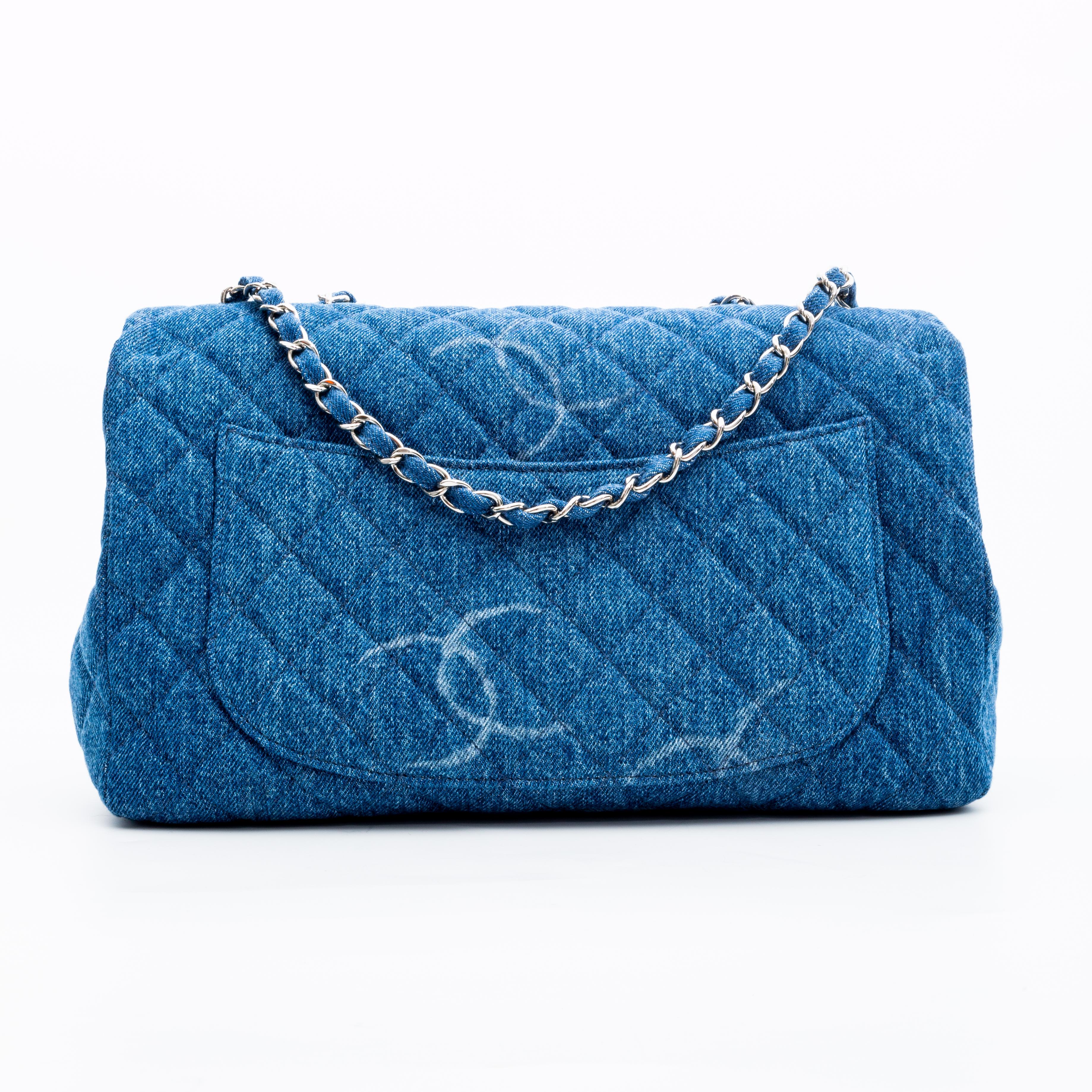 Jumbo Single Flap Bag aus der Herbst/Winter-Kollektion 20B. Diese Umhängetasche ist aus blauem:: rautenförmig gestepptem Denim gefertigt und mit weißen Chanel-Logos bedruckt. Die Tasche hat eine silberne Kette:: die mit Denim verflochten ist:: eine