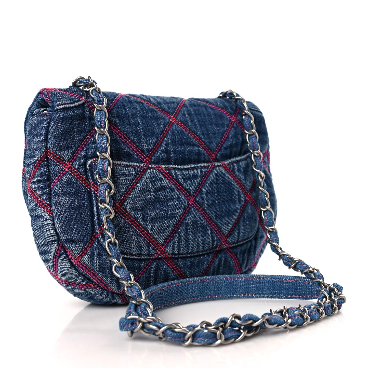 This messenger bag is constructed of diamond quilted blue denim fabric. The bag features silver chain link shoulder straps threaded and a frontal flap with a silver Chanel CC turn lock closure. The flap opens to a fabric interior with