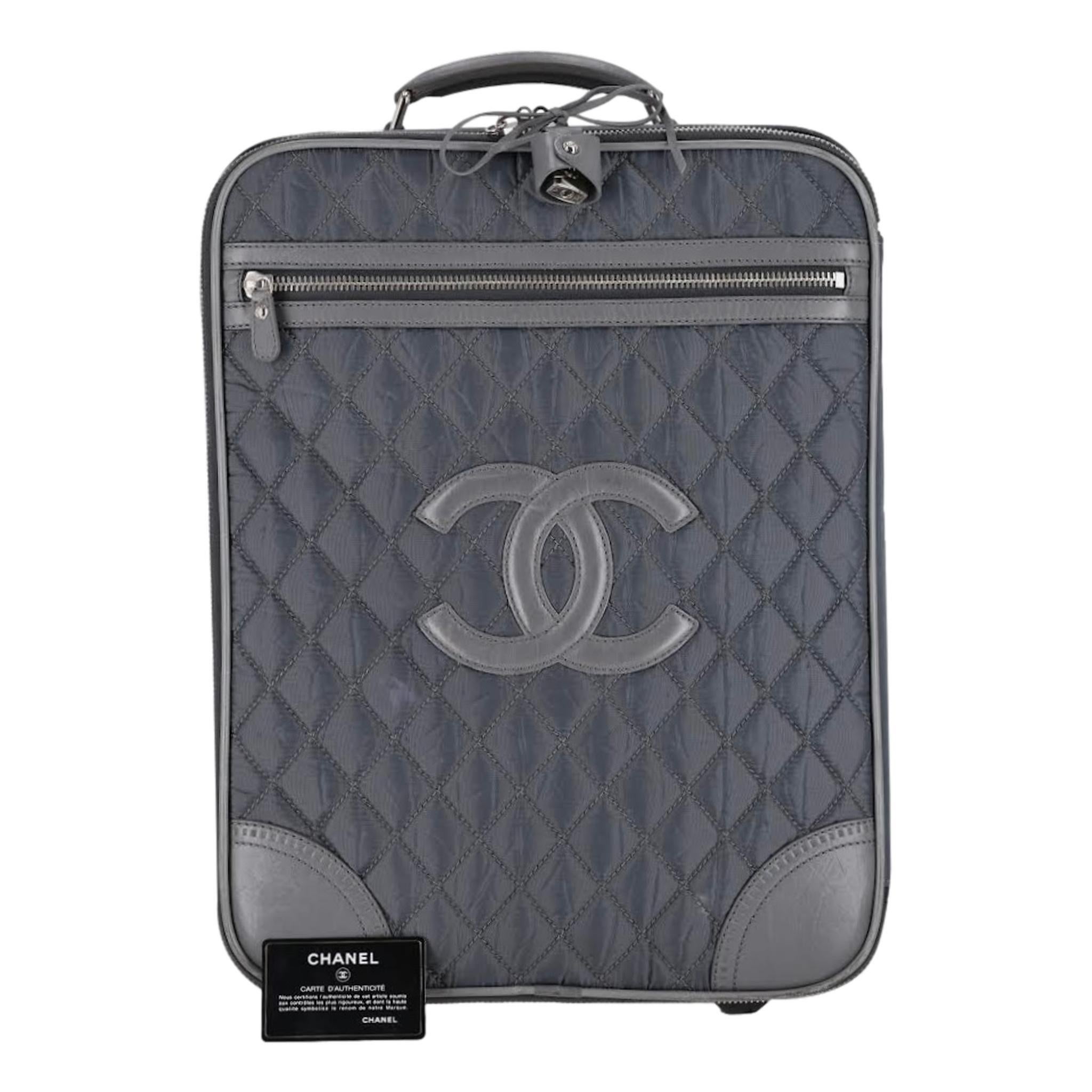 Chanel Diamond Quilted Nylon & Leather 'CC' Trolley Luggage

Grey quilt stitched carry on luggage case with leather, top, sides, base, carry top handle

and 'CC' logo. Top retractable pull handle, wheels at the rear, 'CC' padlock lock.

Zipper full