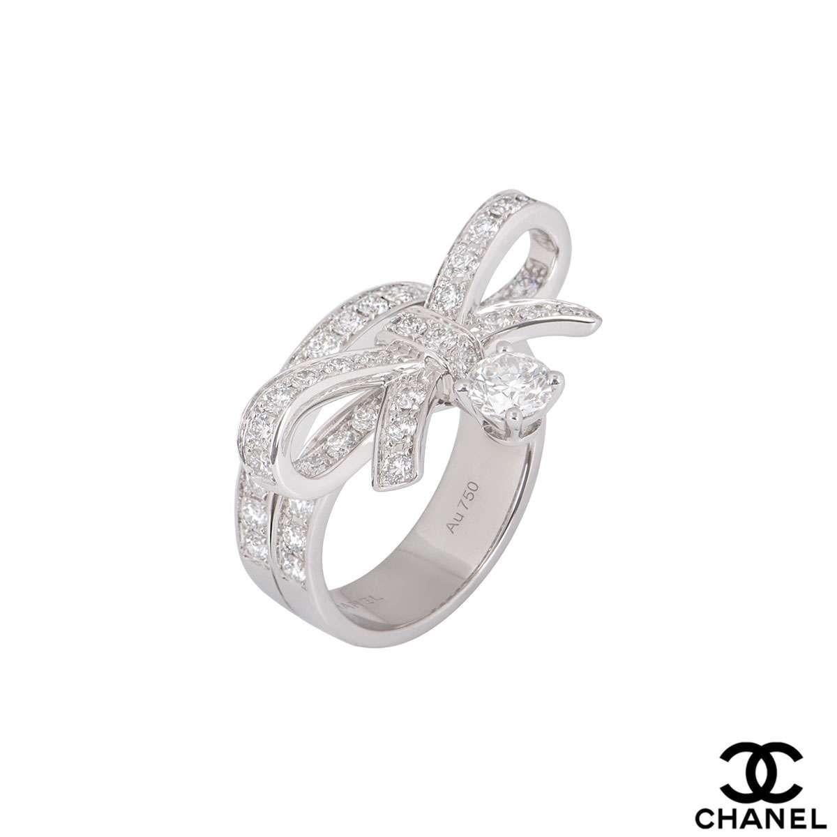 A stunning 18k white gold diamond dress ring from the Ruban collection by Chanel. The ring features a diamond set band and ribbon motif, with a single round brilliant cut diamond weighing 0.40ct suspended below. There are 51 surrounding diamonds