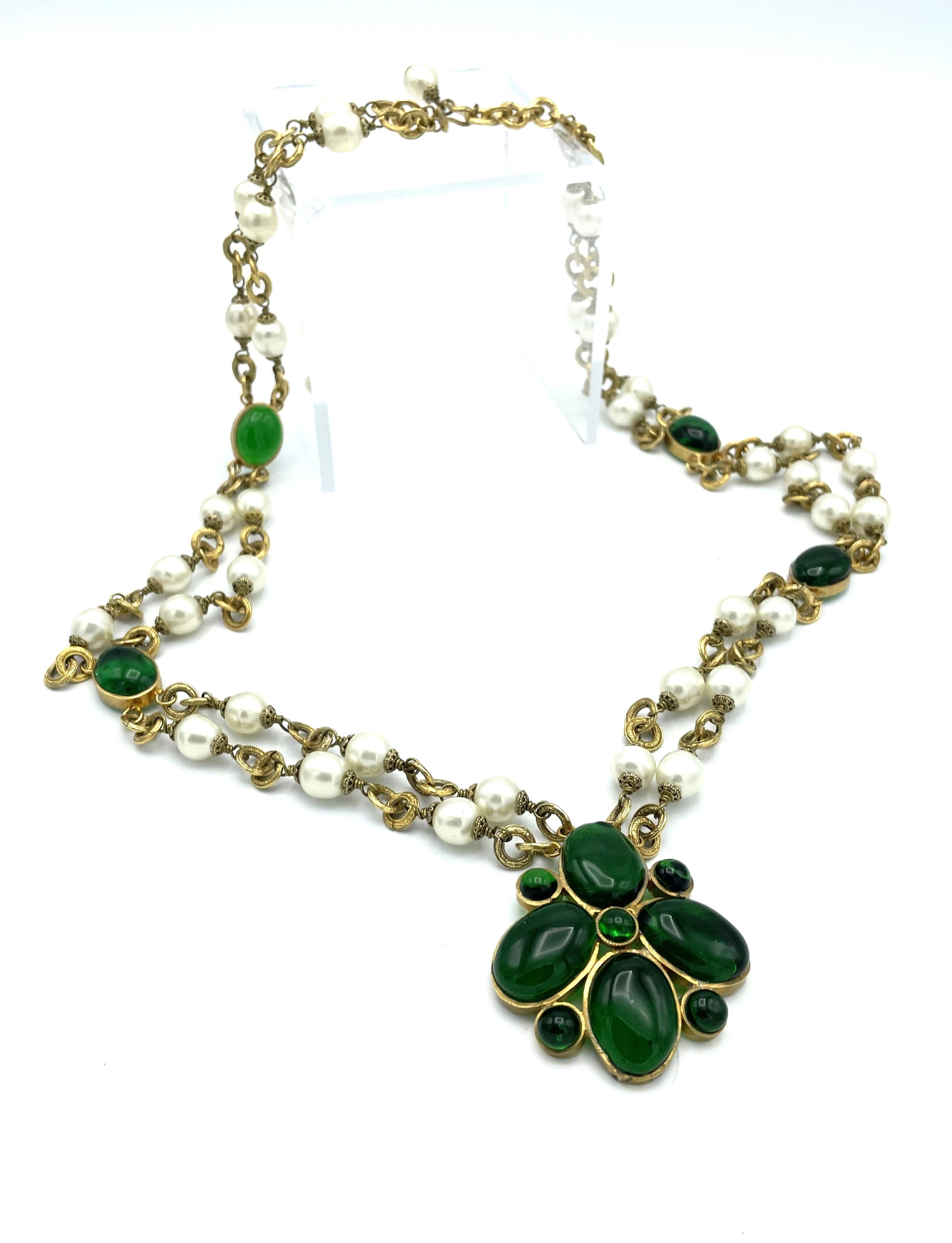 Chanel rare and collectible double strand necklace with a green center pendant from the House of Gripoix . Double strand with faux pearl and between oval green Gripoix.

Measurement : Pendant H 5,3 cm x W 5 cm, whole length with the flower pendant