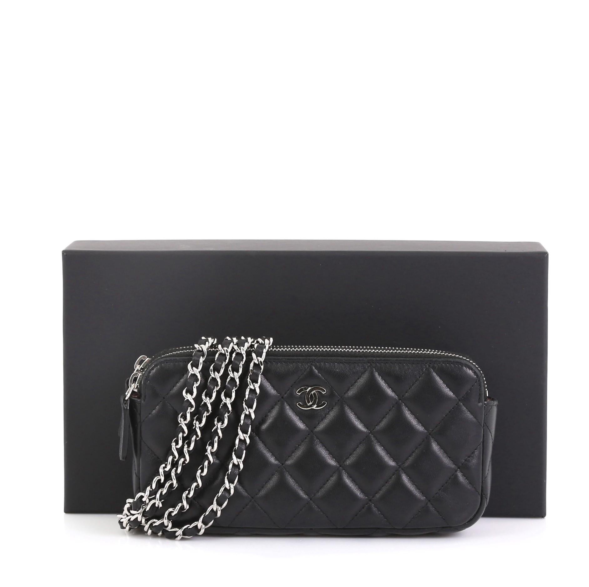 This Chanel Double Zip Clutch with Chain Quilted Lambskin, crafted in black quilted lambskin leather, features a detachable woven-in leather chain strap, front CC logo and silver-tone hardware. Its double zip closures and an open center compartment
