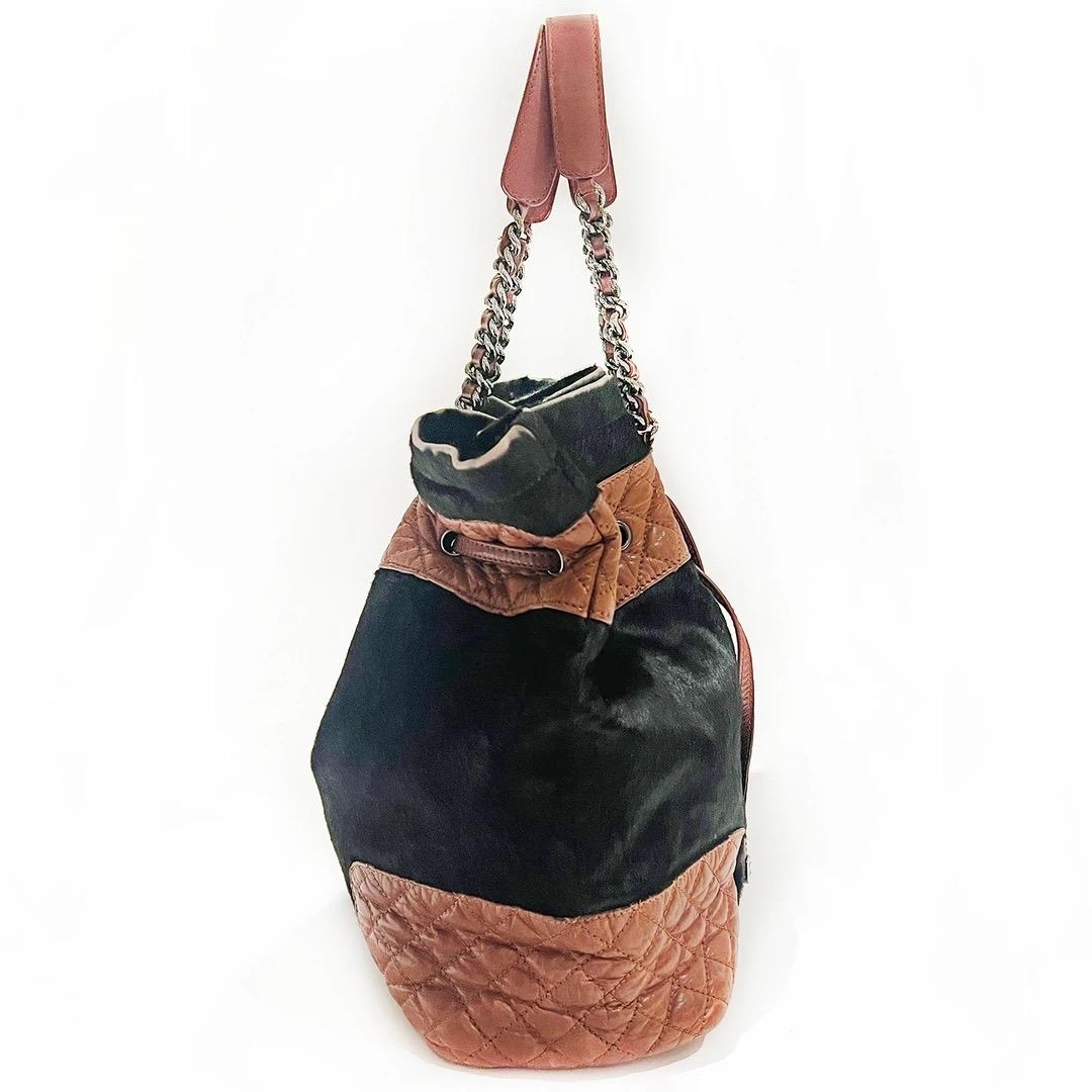 Chanel Drawstring Tote Handbag 
Made in Italy 
Produced in 2005 - 2006
Brown pony hair 
Brown quilted leather detailing 
Brown leather drawstring tote 
Drawstring has gunmetal CC logo hardware 
Handles have gunmetal chain with leather handles