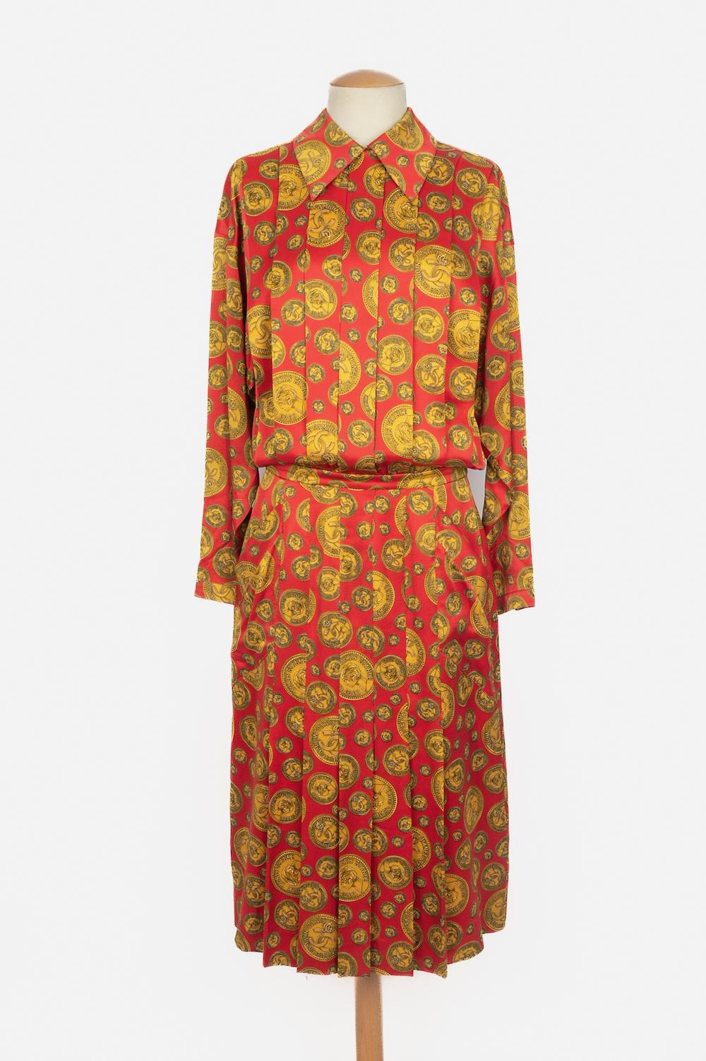 CHANEL - Langärmeliges Seidenkleid mit goldenem Coco-Münzen-Muster auf rotem Grund. Keine Größenangabe, es passt ein 38FR/40FR. Eine Collection'S um 1985 unter der künstlerischen Leitung von Karl Lagerfeld.

Bedingung:
Sehr guter