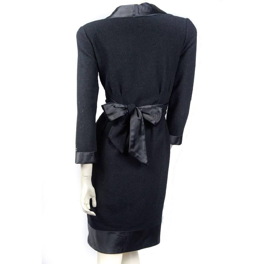 Chanel dress in black wool and silk. Size 42FR. Collection Fall / Winter 2007 . The plogean collar is made of silk and closes like a wrap-around with a black silk waist band.

The rest of the dress is in cold wool and the skirt part closes with a