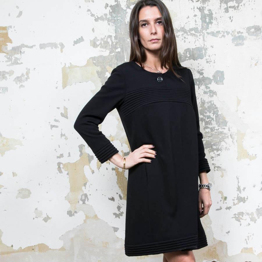 Chanel dress in black wool jersey. Black monogram silk lining. size 38FR

It closes with a 61 cm zipper and a black button.
 
Made in France. It has 2 slit pockets on the sides. In very good condition.

Dimensions flat: Shoulder width 38 cm, width