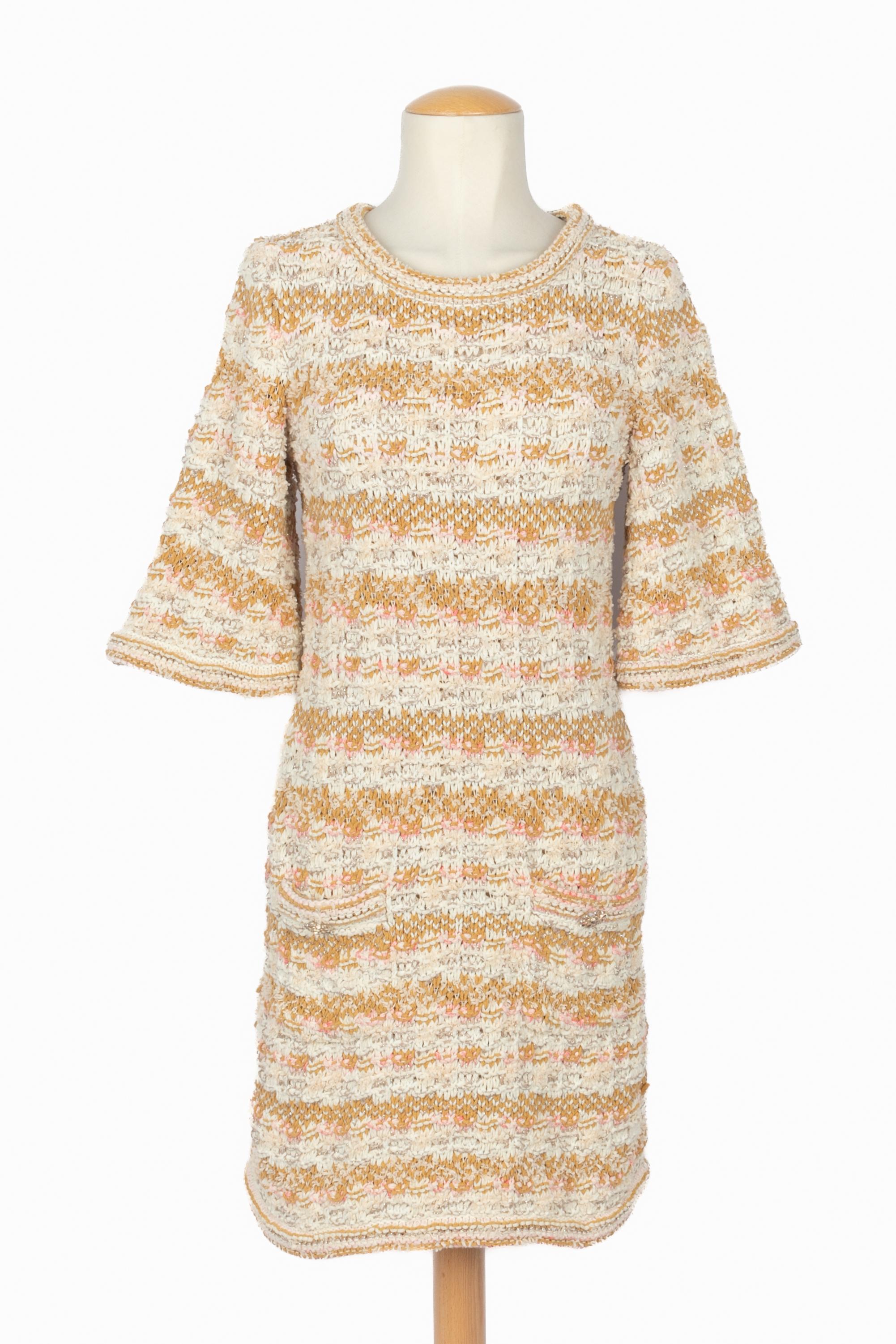 CHANEL - (Fabriqué en Italie) Robe en tweed dans les tons beige, blanc, rose et jaune. Deux poches avec boutons ajourés en métal champagne ornés de résine. Taille 38 FR indiquée. Collection 2017 Resort Paris-Cuba sous la direction artistique de Karl