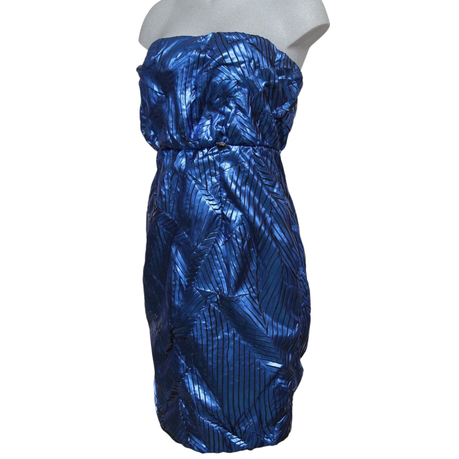 GUARANTEED AUTHENTIC CHANEL 2012 METALLIC BLUE STRAPLESS DRESS

Retail excluding sales taxes $5,220

Design:
- Stunning metallic blue silk strapless dress.
- Below bust, seam higher waistline.
- Gripoix plaque at left waist.
- Around the inside top
