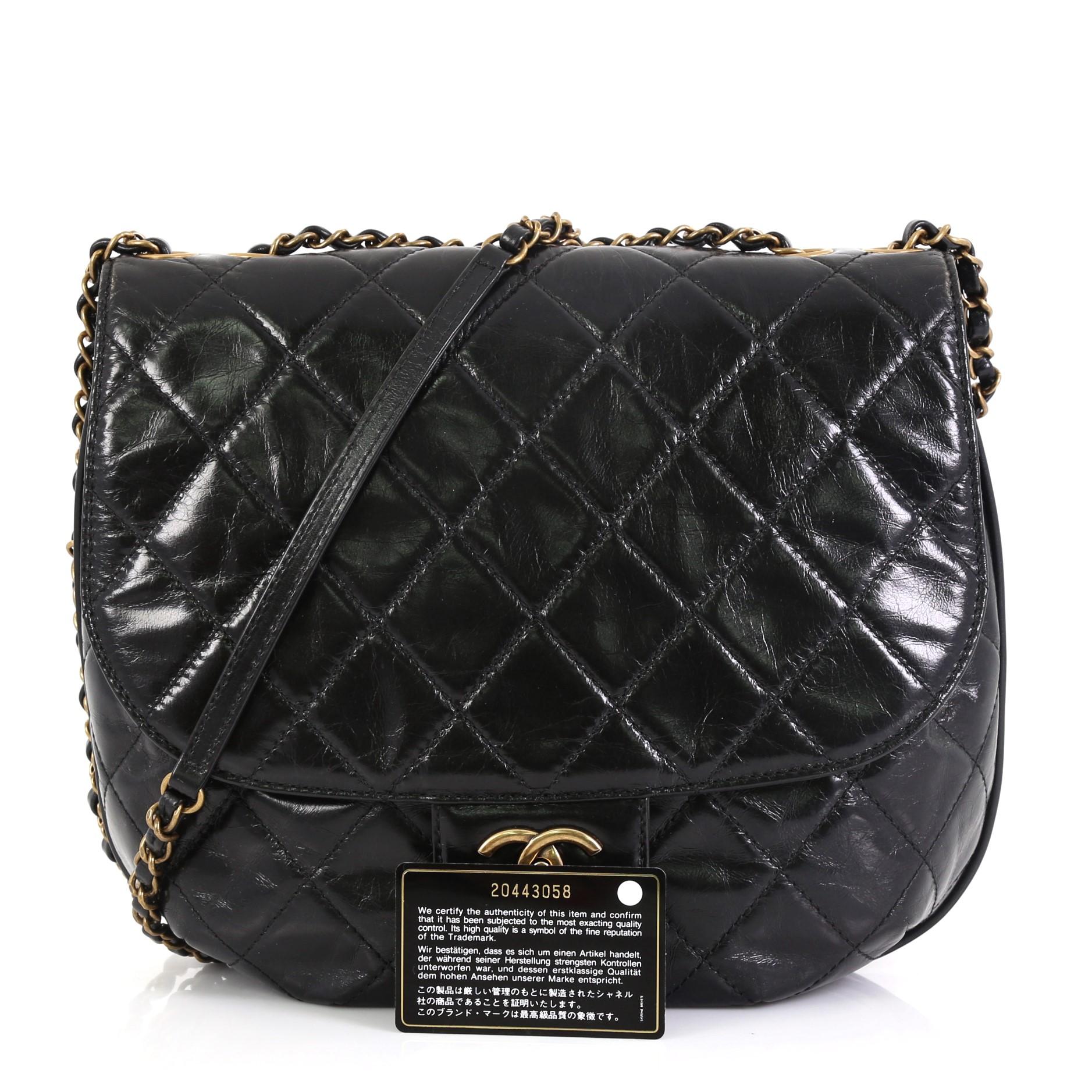 This Chanel Dubai Messenger Bag Quilted Aged Calfskin Medium, crafted from black quilted aged calfskin, features woven-in leather chain strap with leather pad, exterior back slip pocket, frontal flap, slip pocket under flap and aged gold-tone