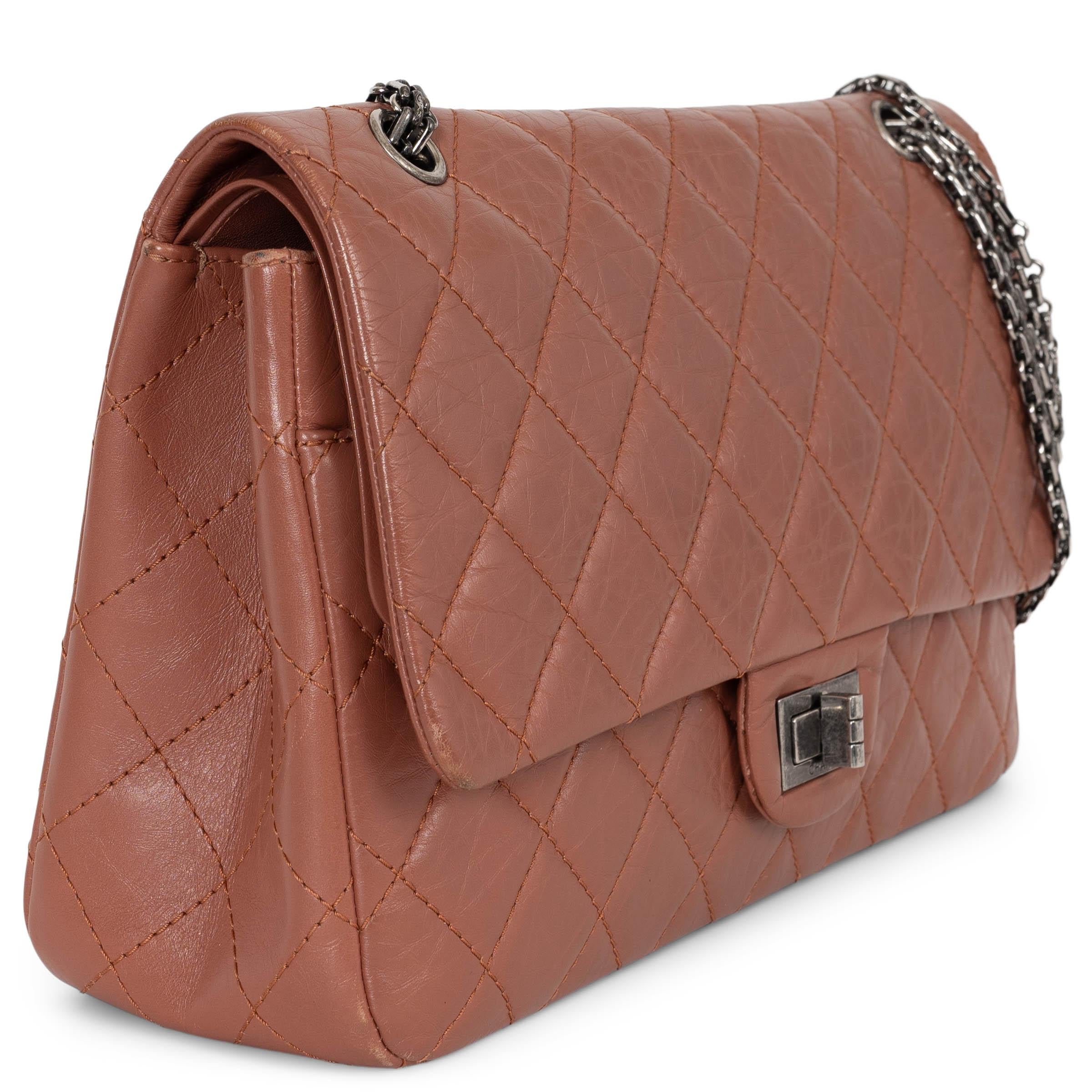This 100% authentic Chanel 2.55 Reissue Maxi Double Flap Bag is crafted from dusty rose aged calfskin, showcasing the iconic diamond quilted stitching. It opens with an aged silver-tone turn-lock, revealing a tonal smooth calfskin interior that