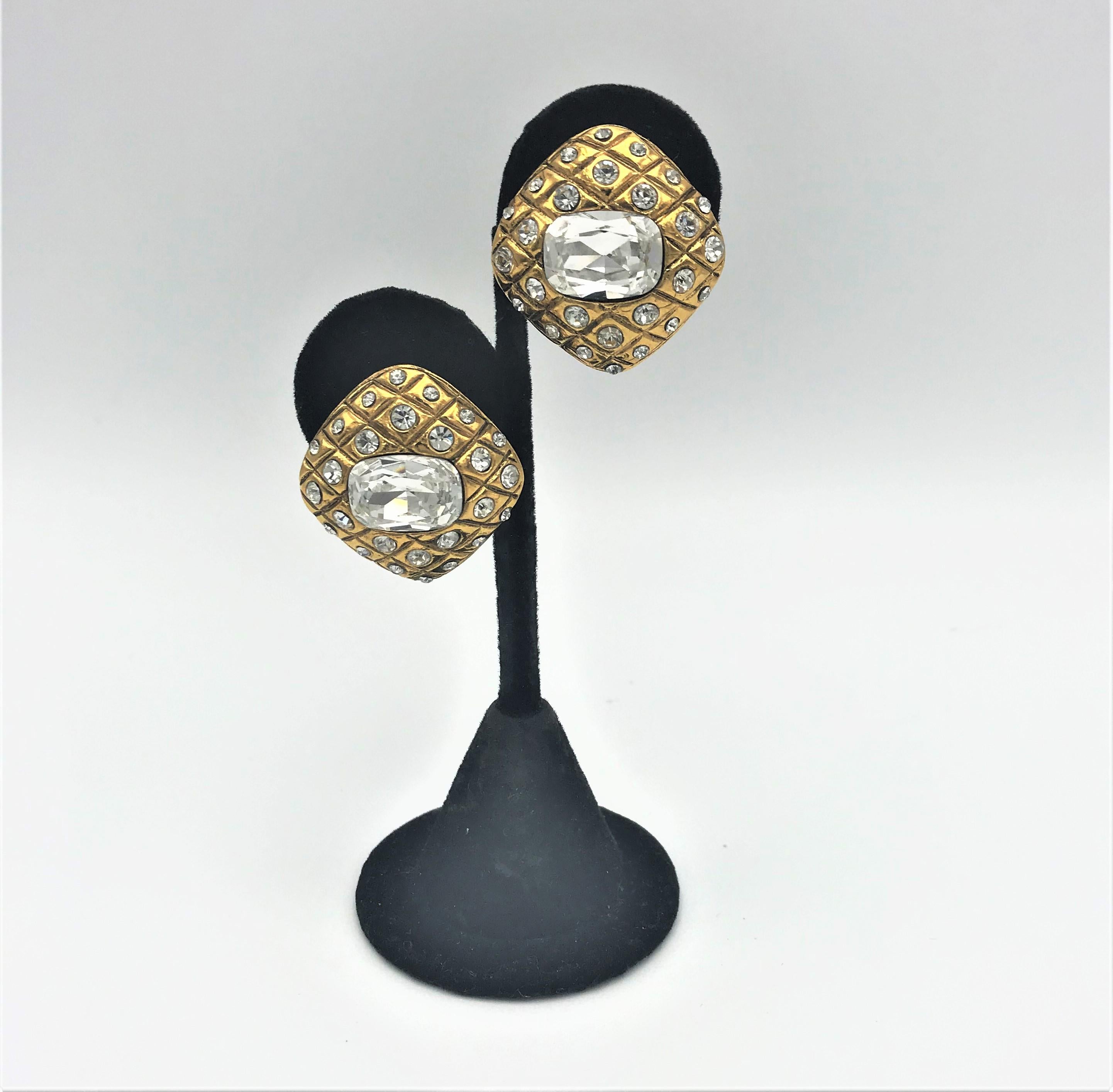 ABOUT
 
Iconic Chanel clip-on earrings, from the 1st collection by Victoire de Castellane. quilted with small rhinestones in between. In the middle there is a large rectangular cut rhinestone. Gold plated. 
Measurement: Size 3 cm x 3 cm, rectangular