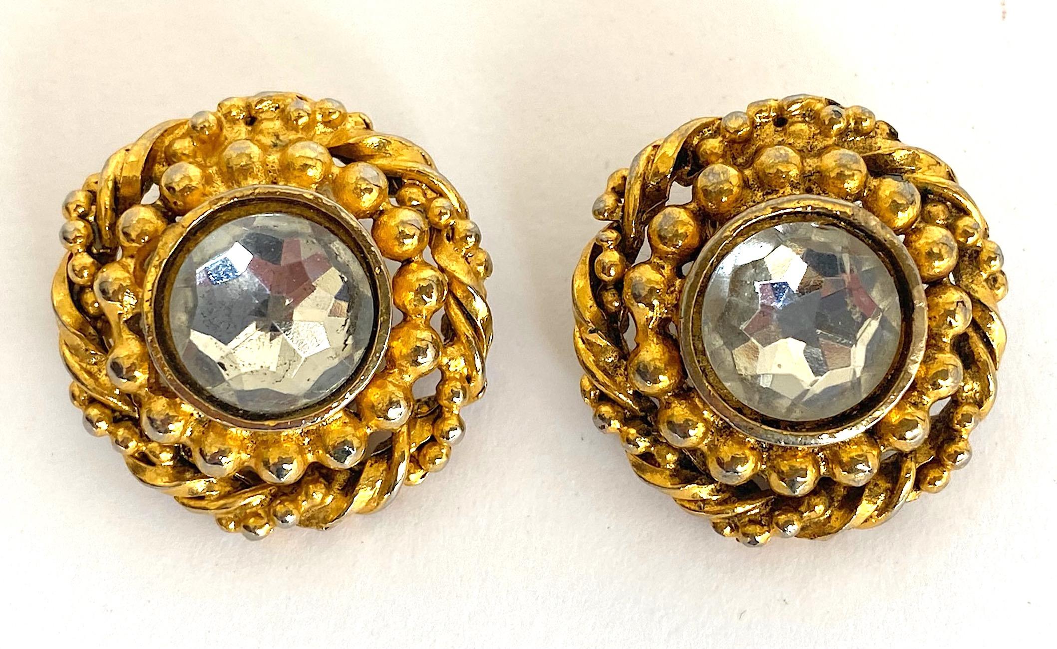 A classic and beautiful pair of pre 1986 Chanel earring. Each is earring is constructed with a central .44 of an inch diameter faceted rose cut and bevel set rhinestone. It is surrounded by a ring of beads floating in a rope twist outer ring. The