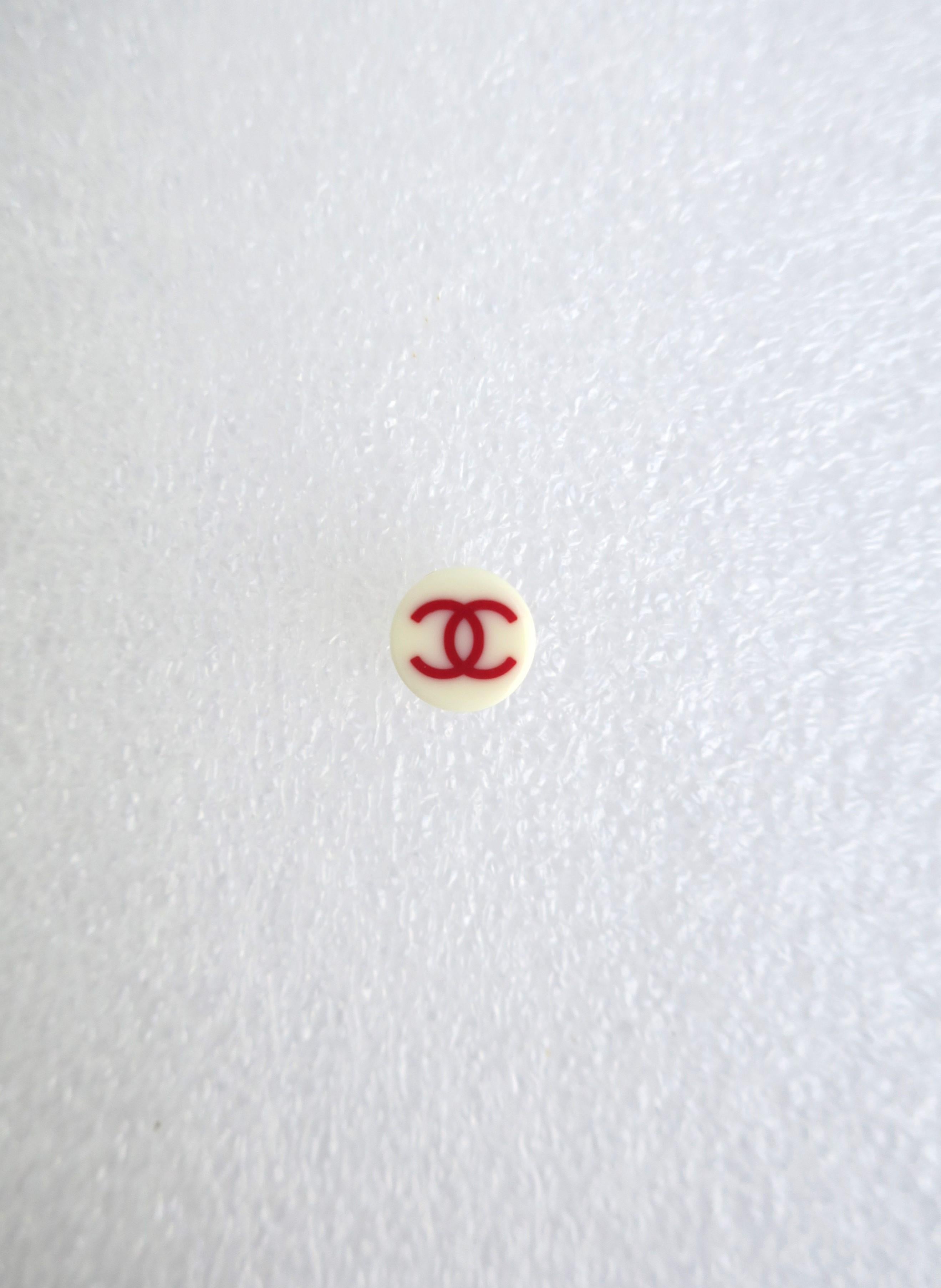 A super chic authentic Chanel earring (1) in white and red resin, 2003, early-21st century. Purchased at the Chanel boutique inside Bergdorf Goodman, New York. Earing is round, white resin with red double interlocking 'C', Chanel's signature logo. A