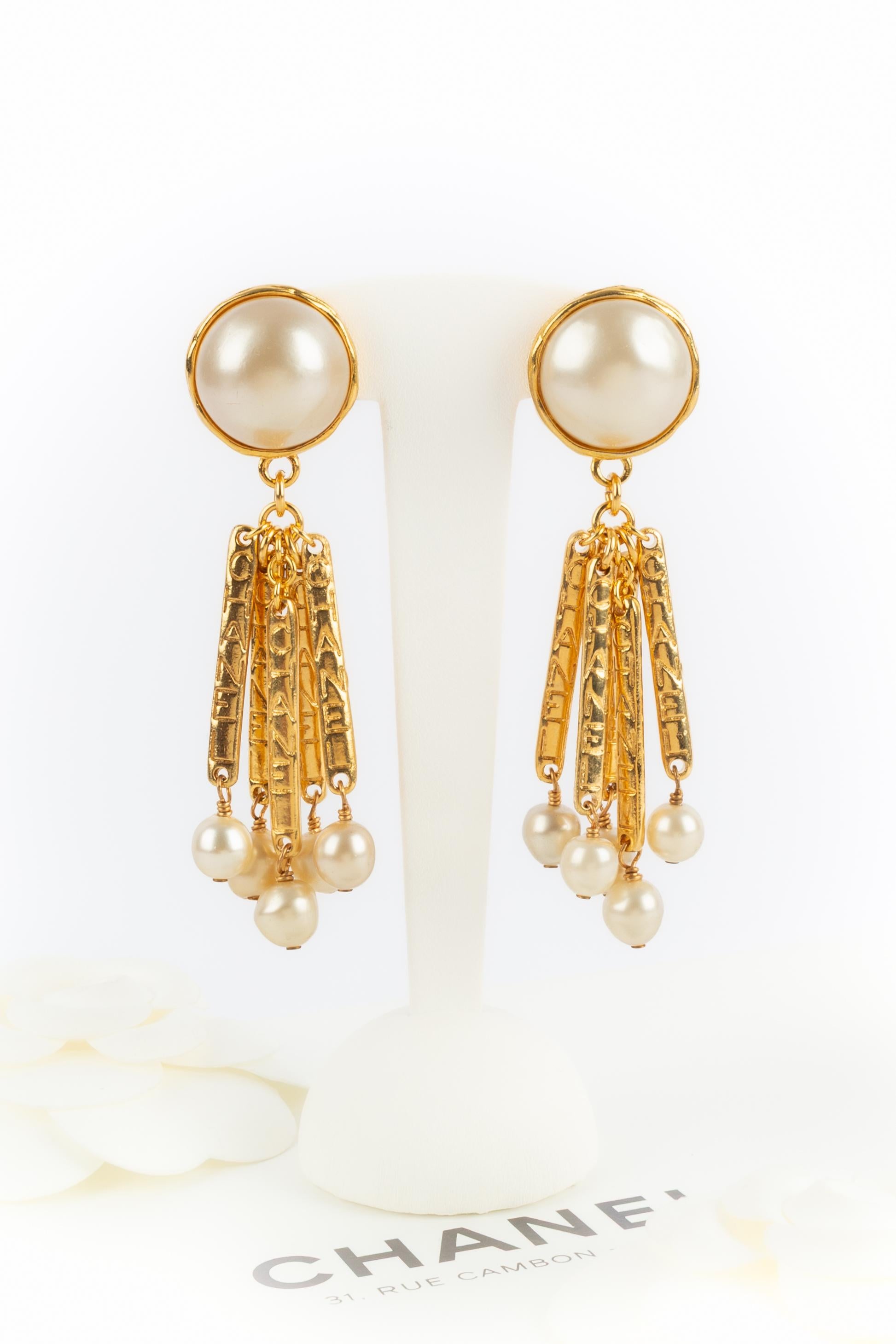 CHANEL - (Made in France) Pendientes de clip de metal dorado con cabujones nacarados y pequeñas perlas de fantasía. Joyas de los años 90 bajo la dirección artística de Karl Lagerfeld.

Estado:
Muy buen estado

Dimensiones:
Longitud: 8 cm

SKU:BOB99