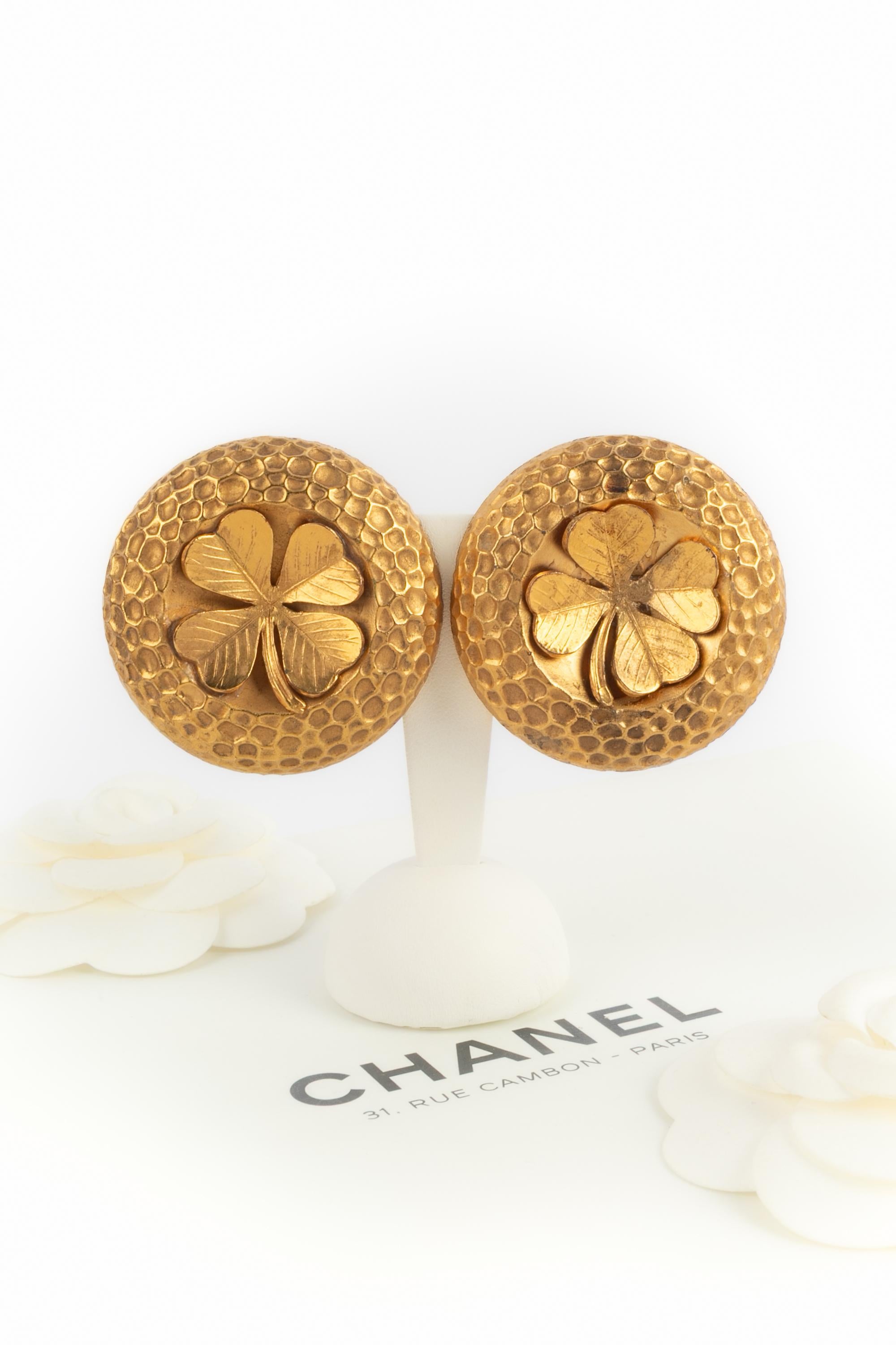 CHANEL - (Fabricado en Francia) Pendientes de clip de metal dorado grabado y batido, centrados con tréboles de cuatro hojas. Una Colección hacia 1992 bajo la dirección artística de Karl Lagerfeld.

Estado:
Muy buen estado

Dimensiones:
Diámetro: 4.8