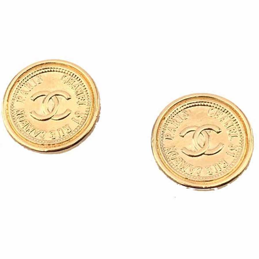 The earrings are clips from Maison CHANEL. They have a round shape, similar to metal coins gilded with fine gold, with the central emblem of the CC brand, surrounded by the essential address CHANEL, 31 Rue Cambon Paris.
The clips are vintage and in