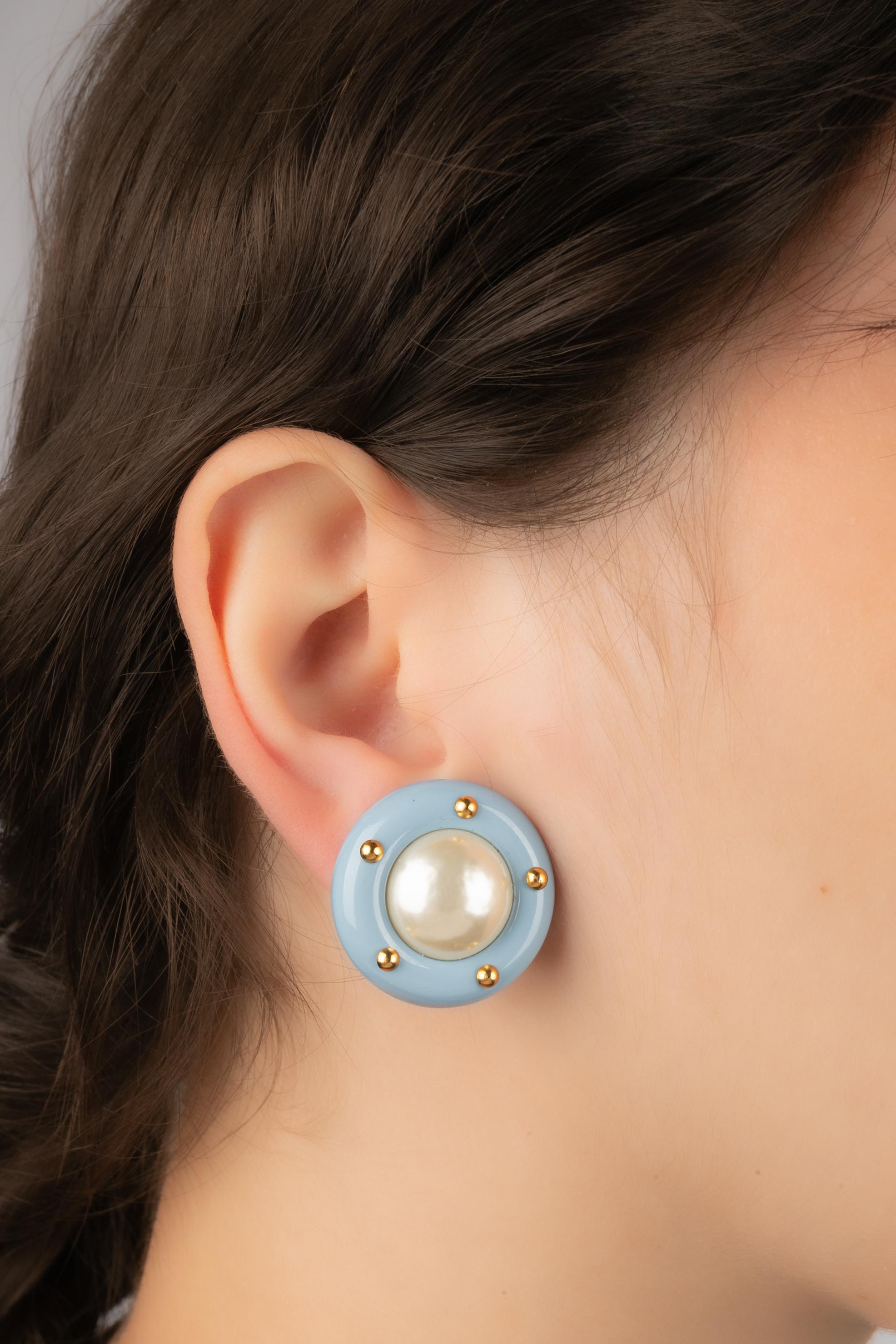 CHANEL - (Made in France) Golden metal clip-on earrings with blue bakelite and costume pearly cabochons. 1996 Cruise Collection under the direction of Karl Lagerfeld.

Condition:
Very good condition

Dimensions:
Diameter: 2.5 cm

SKU:BOB58