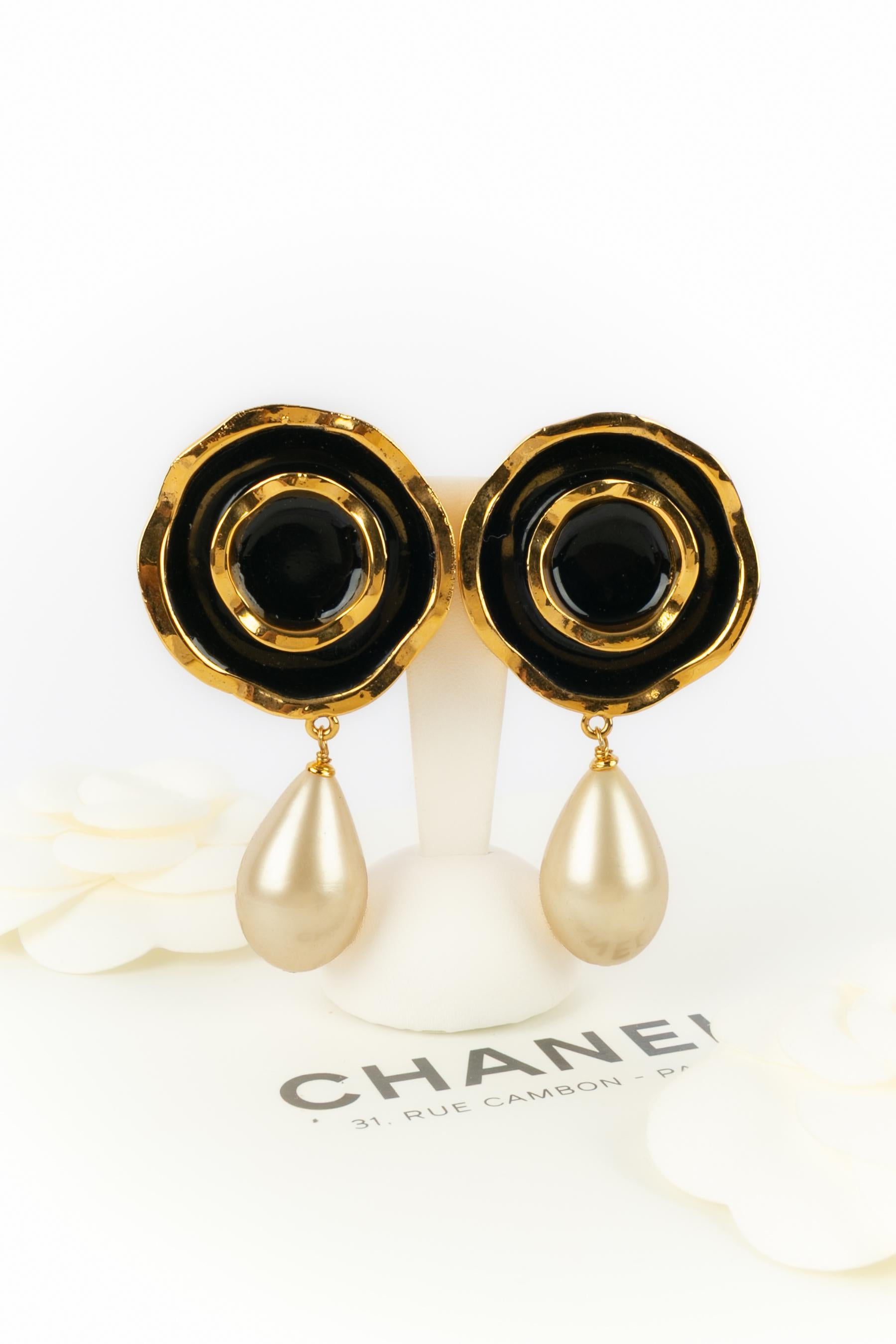 CHANEL - (Made in France) Goldene, schwarz emaillierte Ohrringe aus Metall mit einem Tropfen aus Perlmutt. Eine Haute Couture Collection'S.

Bedingung:
Sehr guter Zustand

Abmessungen:
Länge: 8 cm

SKU:BOB77