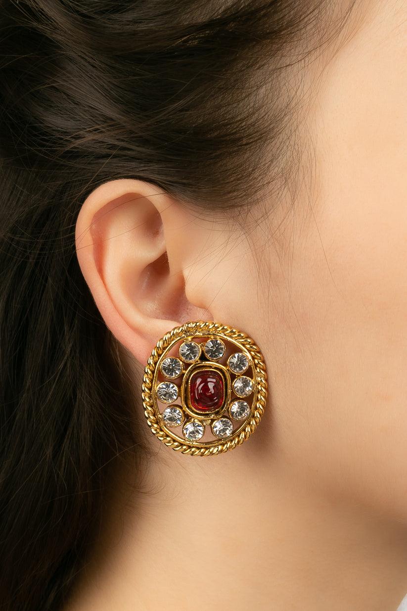 Chanel - (Made in France) Earrings in gold metal paved with rhinestones and centered by a cabochon in red glass paste. Collection 2cc3

Additional information:
Dimensions: 3.5 H cm

Condition: 
Very good condition

Seller Ref number: BOB113