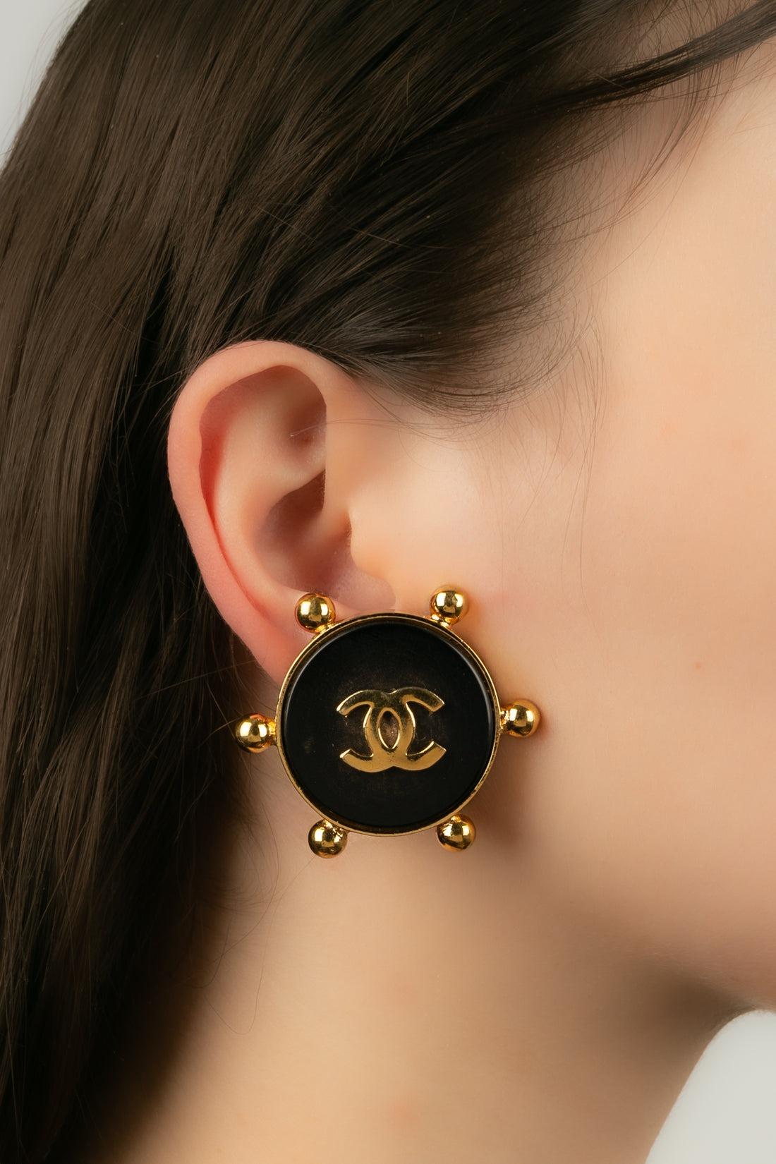 Chanel - Earrings in golden metal and black bakelite.

Additional information:
Condition: Very good condition
Dimensions: Circumference: 4 cm

Seller Reference: BOB18