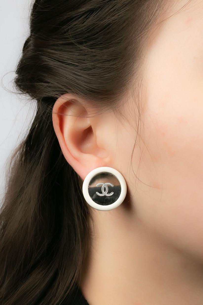 Chanel - (Made in France) Earrings clips dress in white resin and mirror engraved with a cc logo. Cruise Collection 1995.

Additional information:
Dimensions: Ø 2.3 cm
Condition: Very good condition
Seller Ref number: BOB62