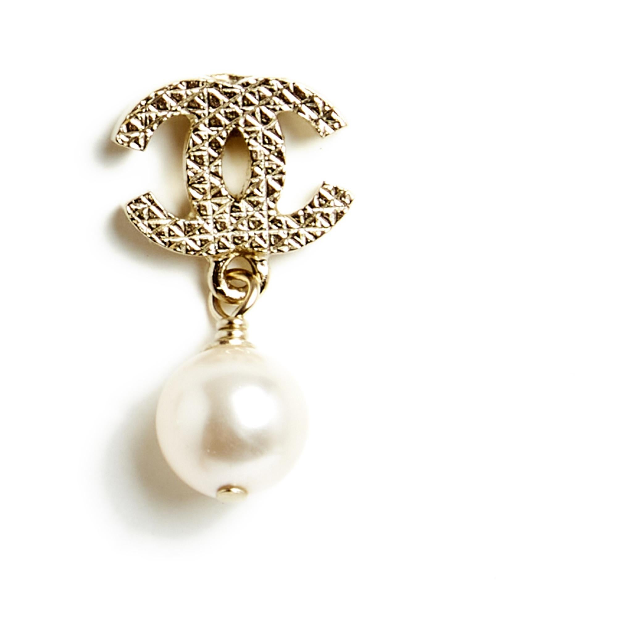 Chanel stud earrings composed of a Chanel CC logo in finely quilted gold metal and a round fancy pearl pendant. Width 1.15 cm x height 2.35 cm. The earrings are delivered without invoice or original packaging but they are in excellent condition,