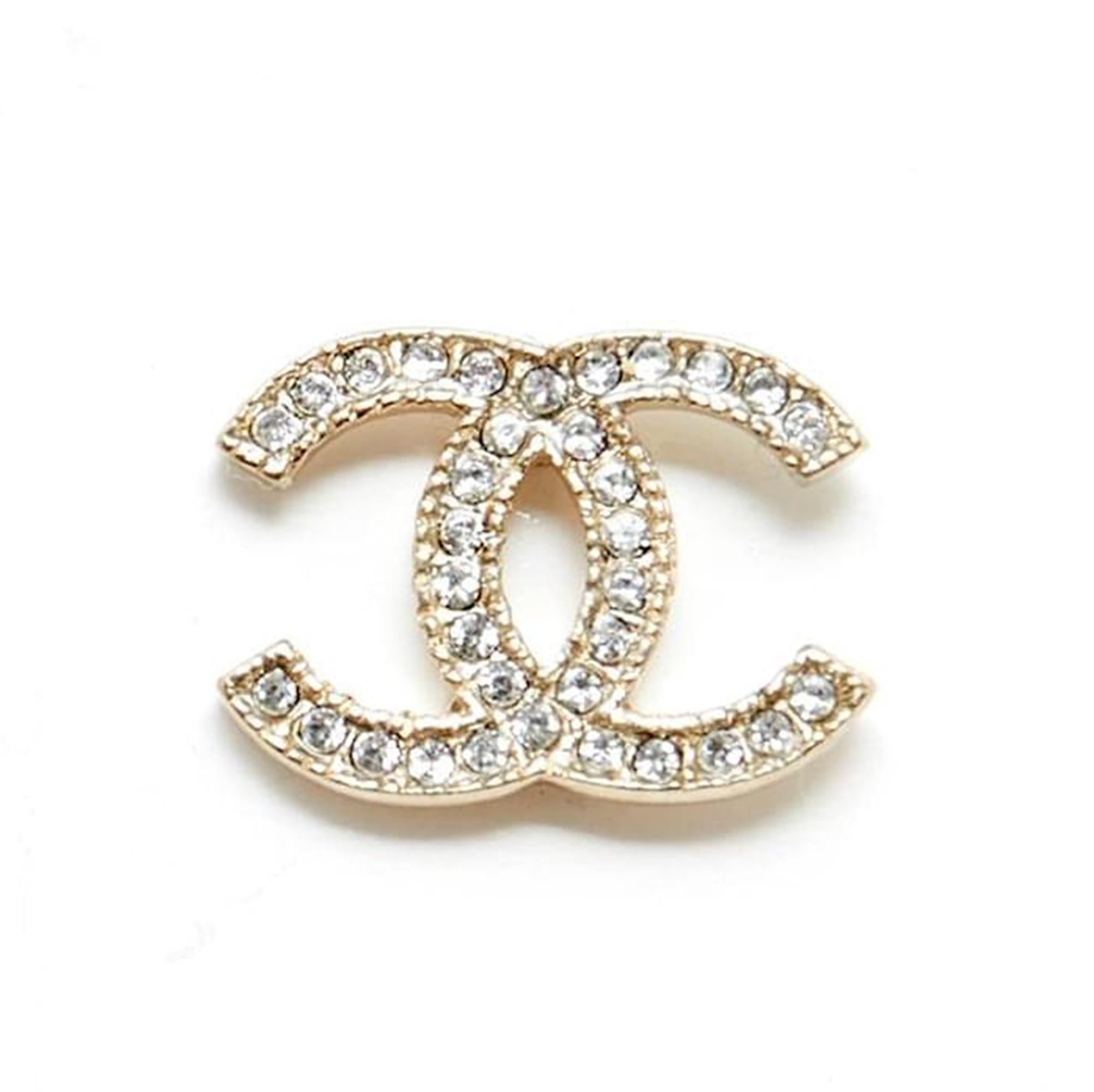 Chanel stud earrings in slightly gold metal (between gold and silver) with the CC symbol inlaid with small white rhinestones. Width 1.55 cm x height 1.15 cm. The curls are delivered without original packaging or invoice, they are in perfect
