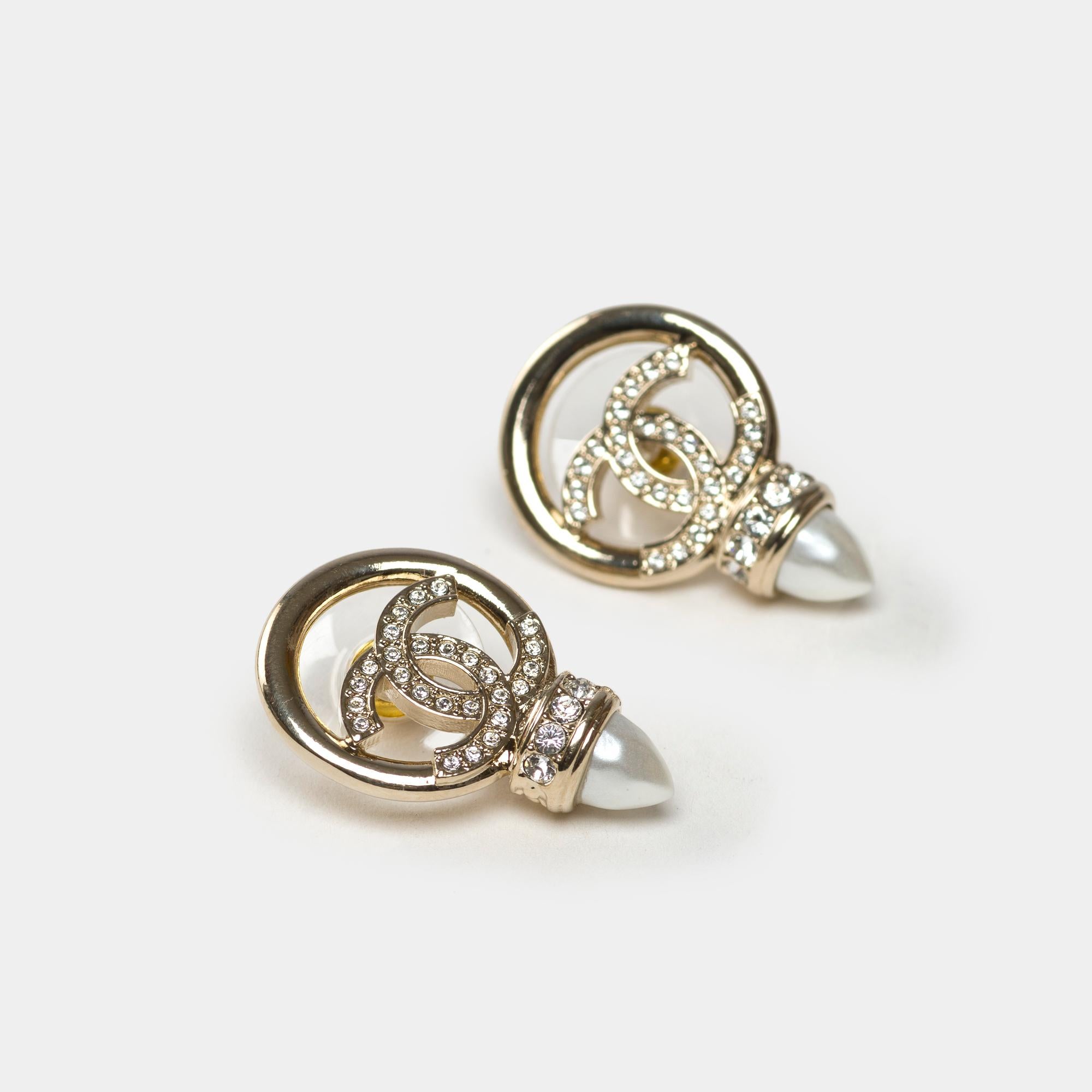 Tipo di gioiello: Orecchini
Marchio: Chanel
Model: CC
Materiale: Metallo, perle e cristalli
Colore: oro e bianco
Dimensioni: 2,5 cm
Peso: 10 gr
Condizioni:   Condit nuovo - mai indossato
Riferimento: 101830
venduto senza confezione originale