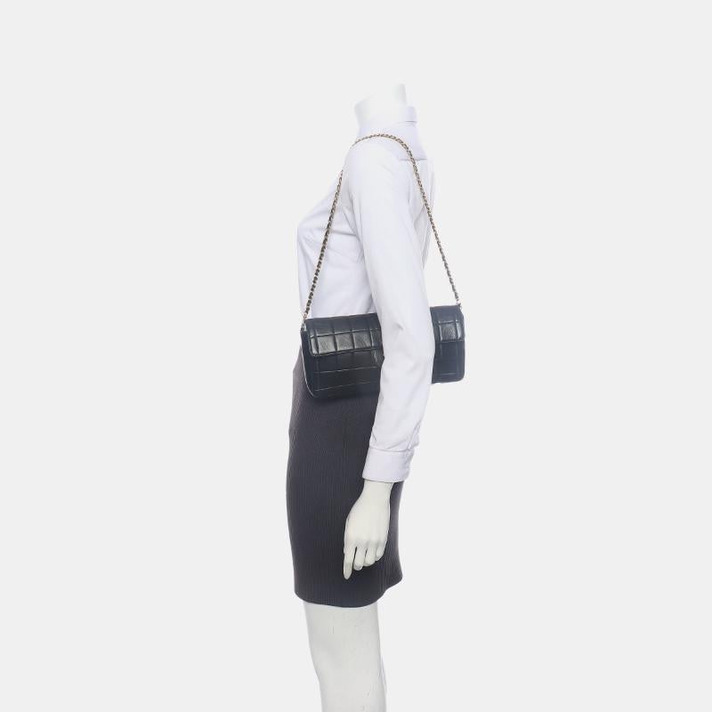 Chanel East West Chocolate Bar Black Leather Blue Interior
 These are professional photos of the actual bag.
 This charming Vintage Chanel East West Leather Shoulder Bag is a stylish mix of classy and casual. The elongated shape gives its 